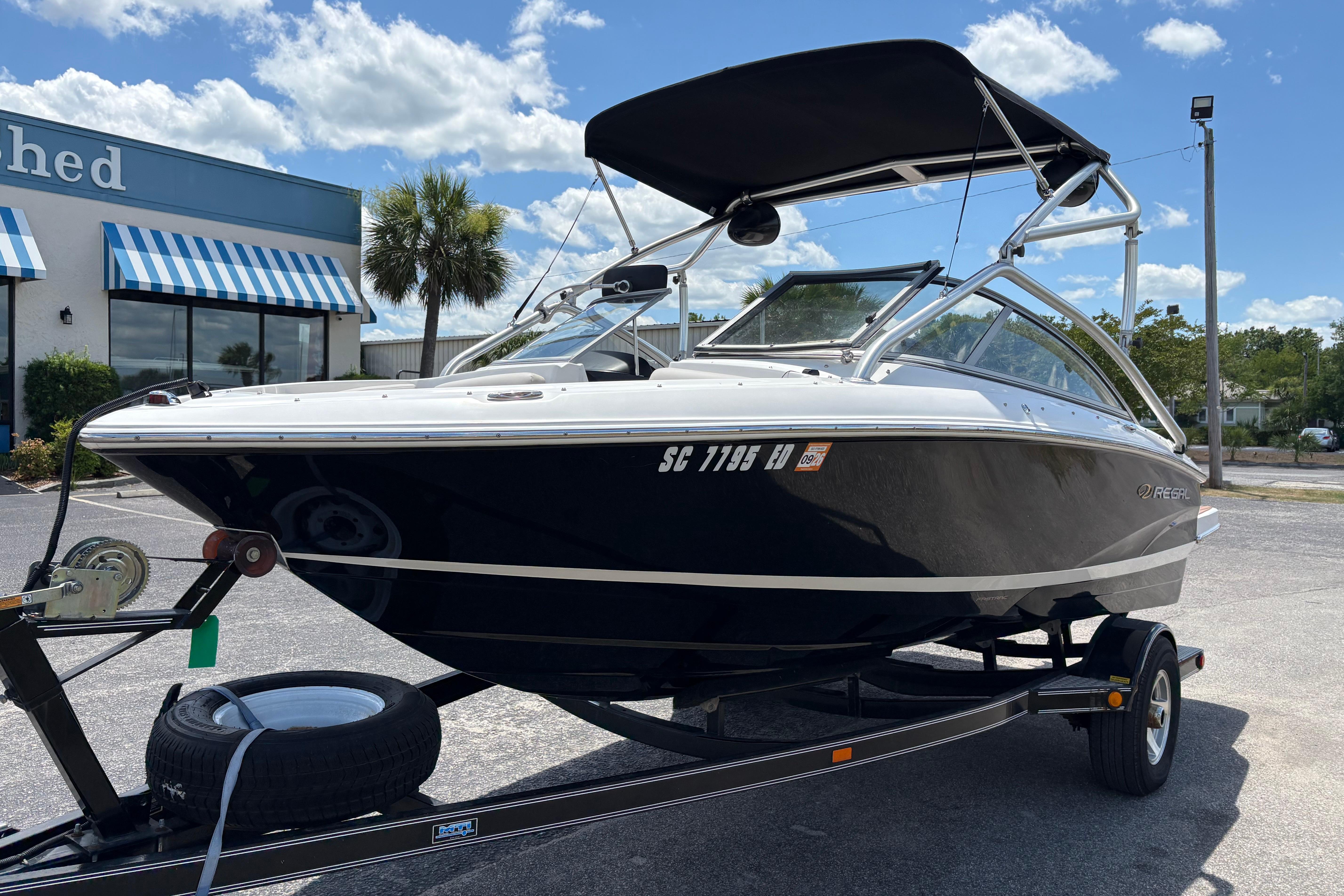 2008 Regal 1900 Bowrider boat on trailer, parked outdoors under a sunny sky.