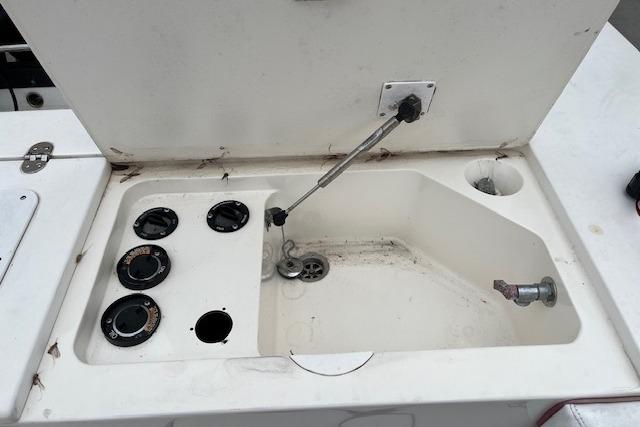 2001 Fountain 38 Center Console boat compartment with open hatch and control dials.
