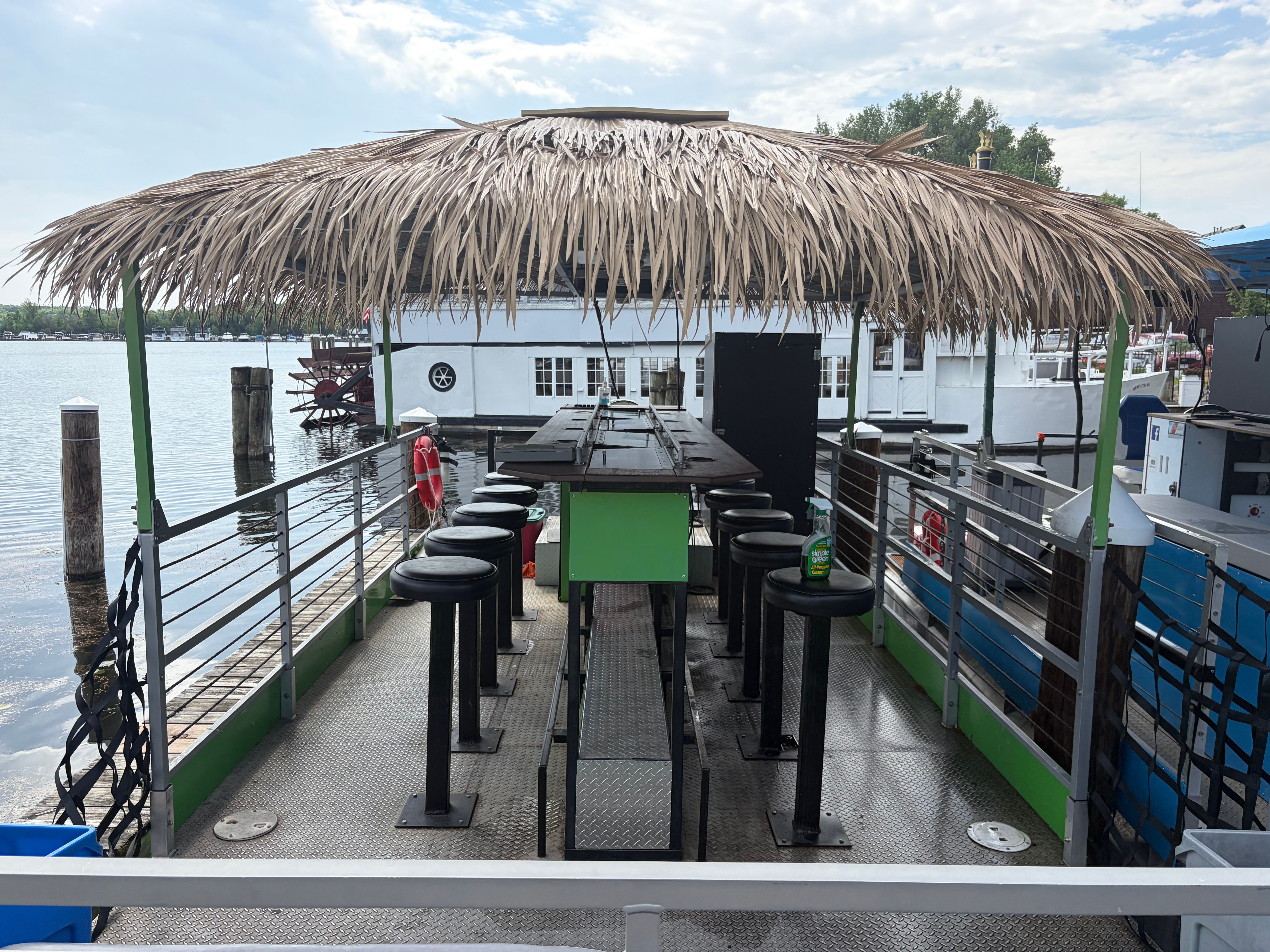 Cascade Cycleboat 2018 with straw roof and bar stools on water.