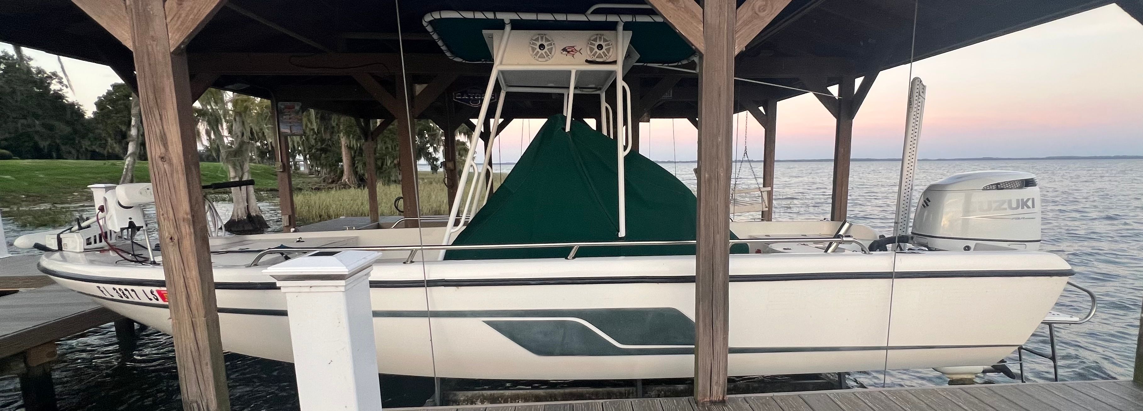 1999 Skeeter ZX2200 boat under wooden shelter by the lake.