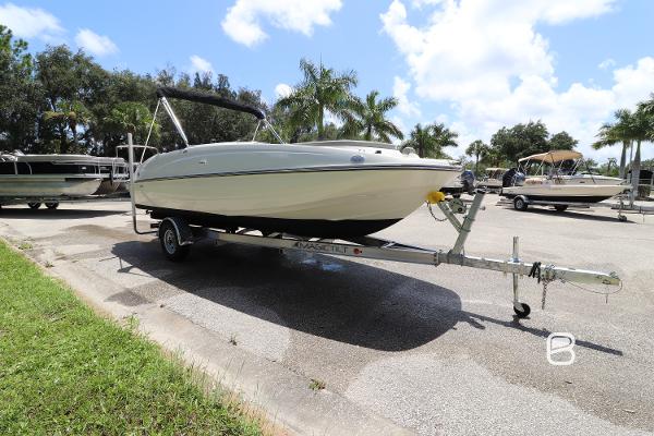 2018 Bayliner 210 DB boat on trailer, parked outdoors under a sunny sky.