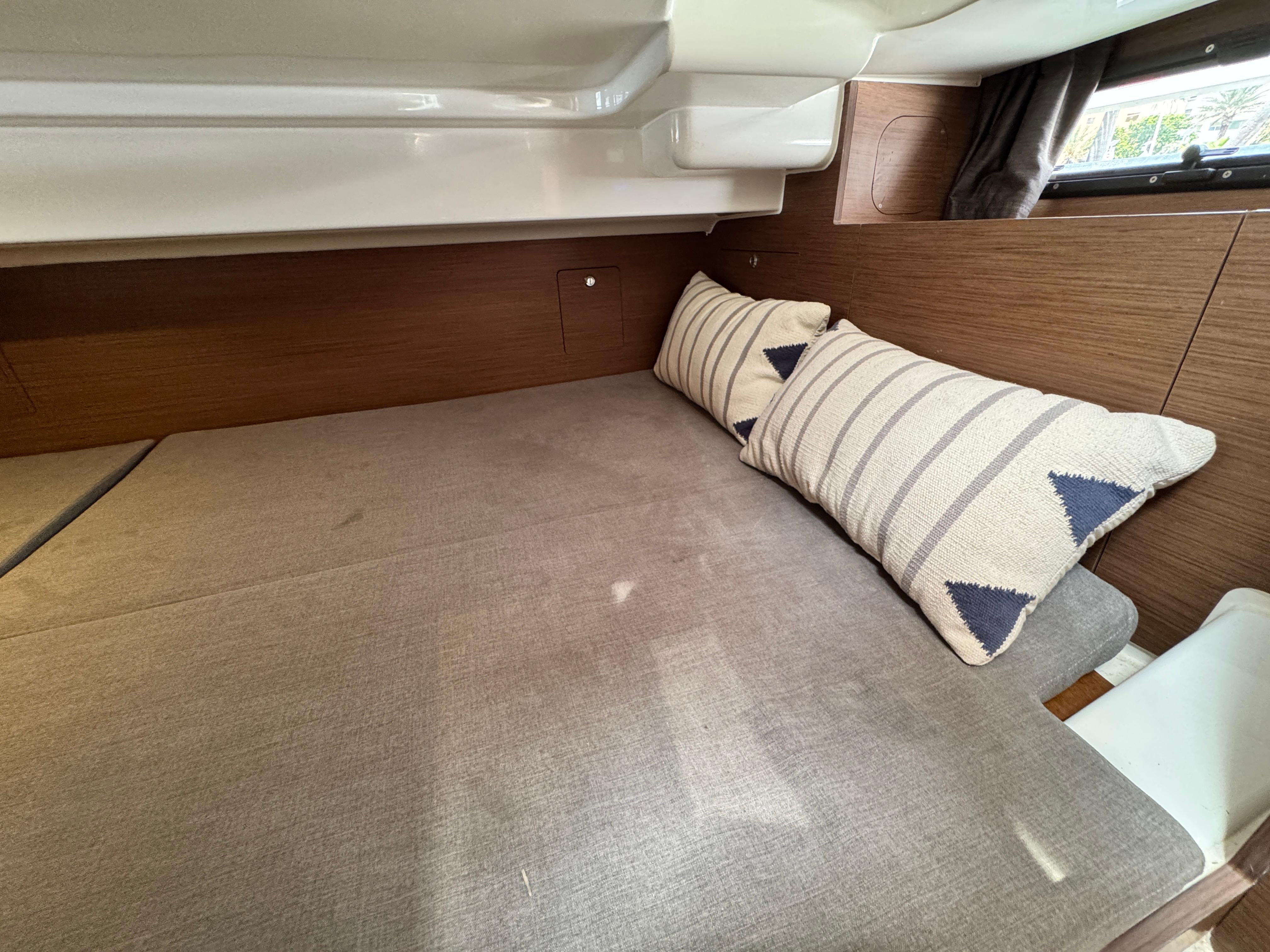 Interior cabin of 2022 Beneteau Flyer 9 SUNdeck with cozy bedding and pillows.