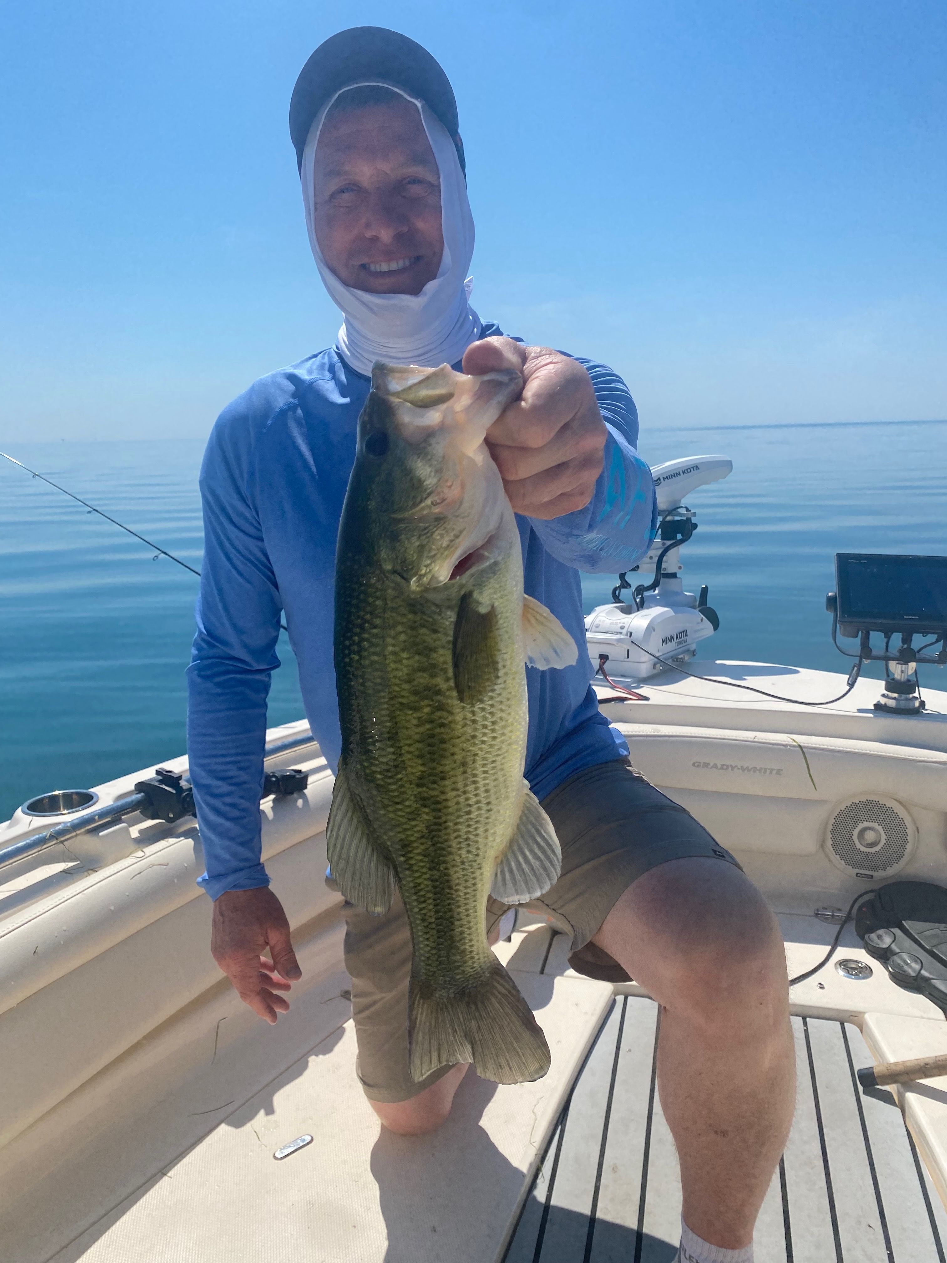 Angler holding fish on Grady-White Freedom235 boat, 2018 model.