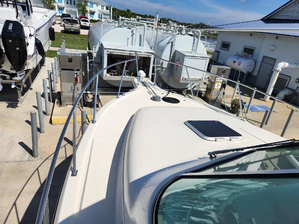 2005 Pursuit 3070 Offshore Center Console boat docked at a marina.