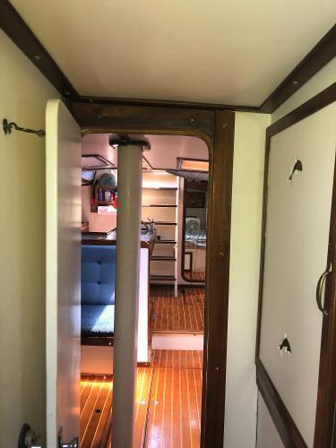 Interior of a 1993 Columbia Cutter sailboat, featuring wooden flooring and cozy seating.