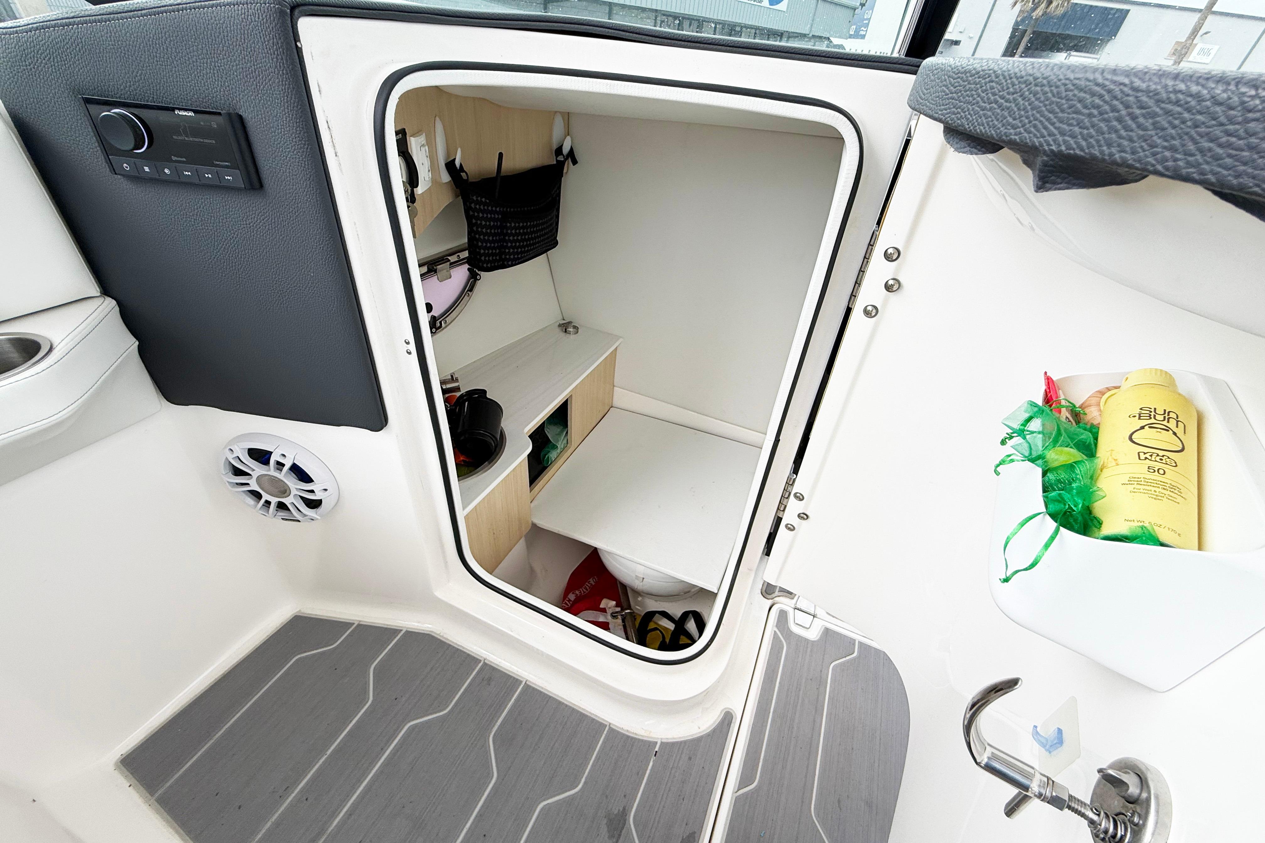 2024 Regal LX4 boat interior with storage compartment and sunscreen bottle.