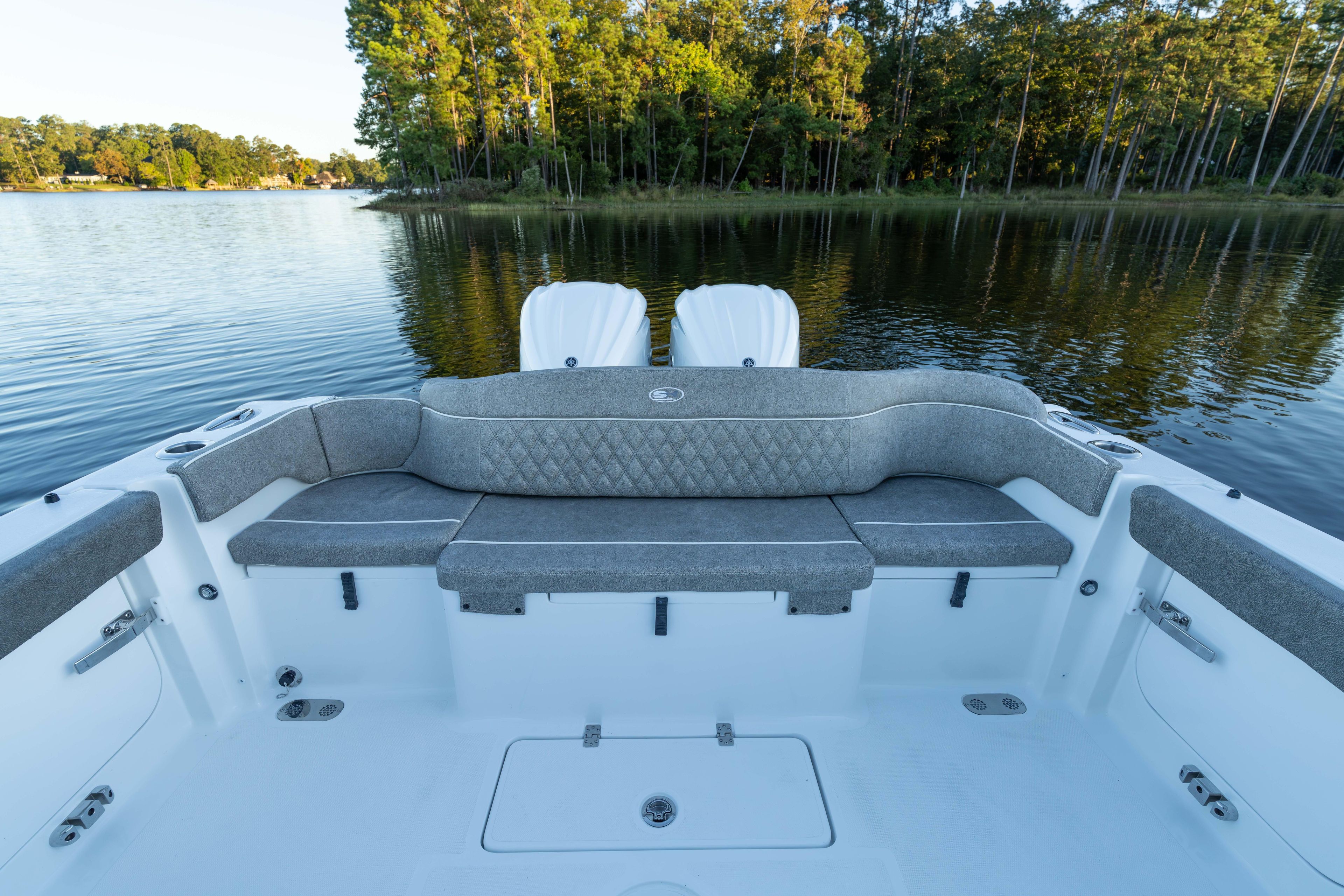 2026 Sea Hunt Ultra 275 Coffin Box boat interior with cushioned seating on a serene lake.