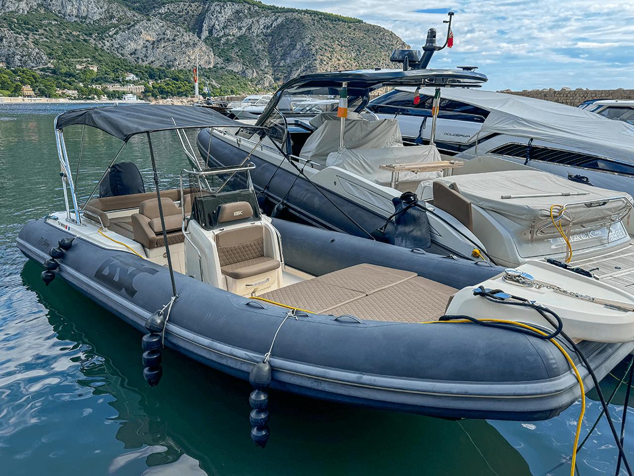 2019 BSC 78 inflatable boat docked in a scenic marina with mountainous backdrop.