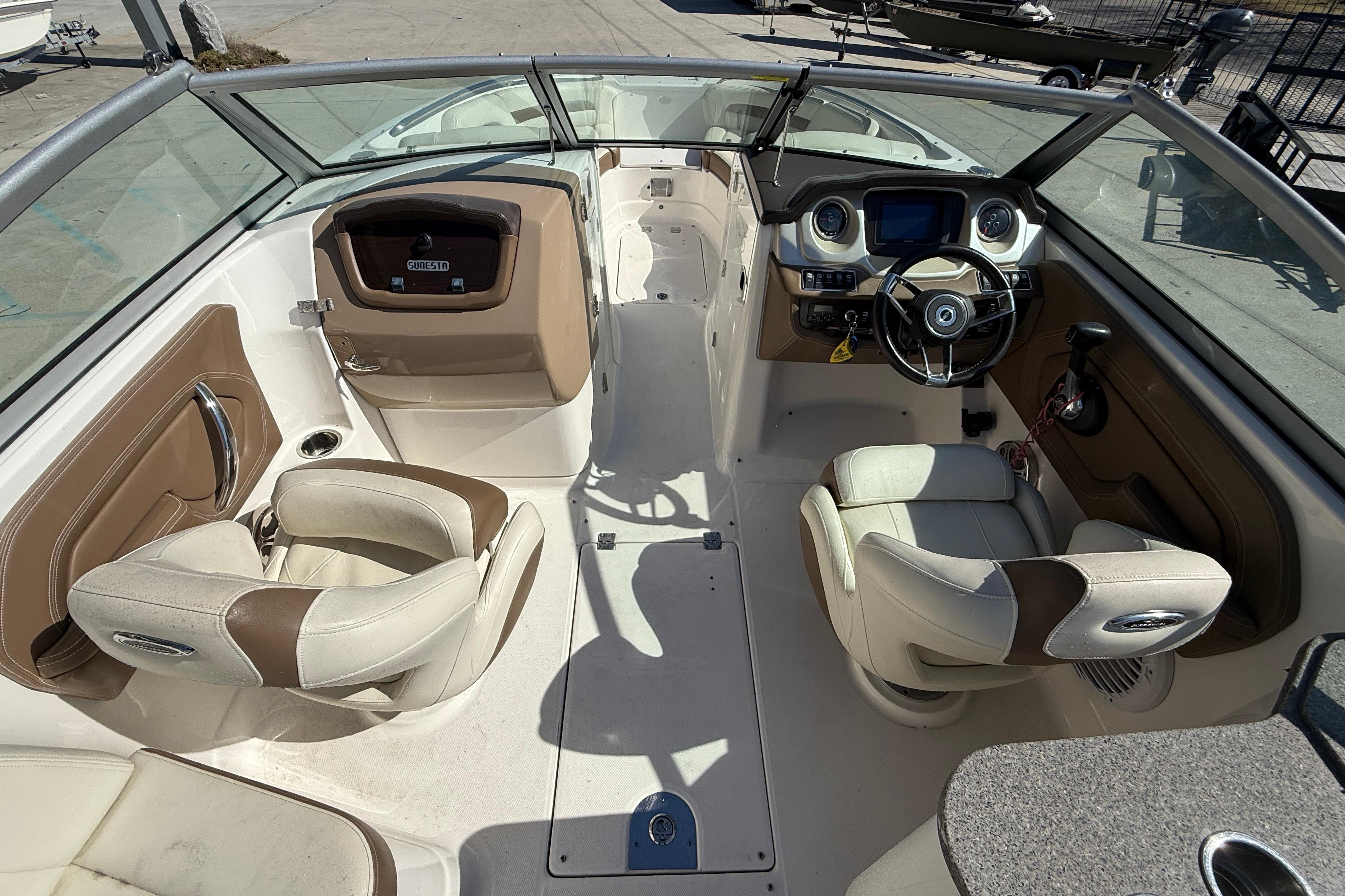 2014 Chaparral 264 Sunesta boat interior with dual captain's chairs and modern dashboard.