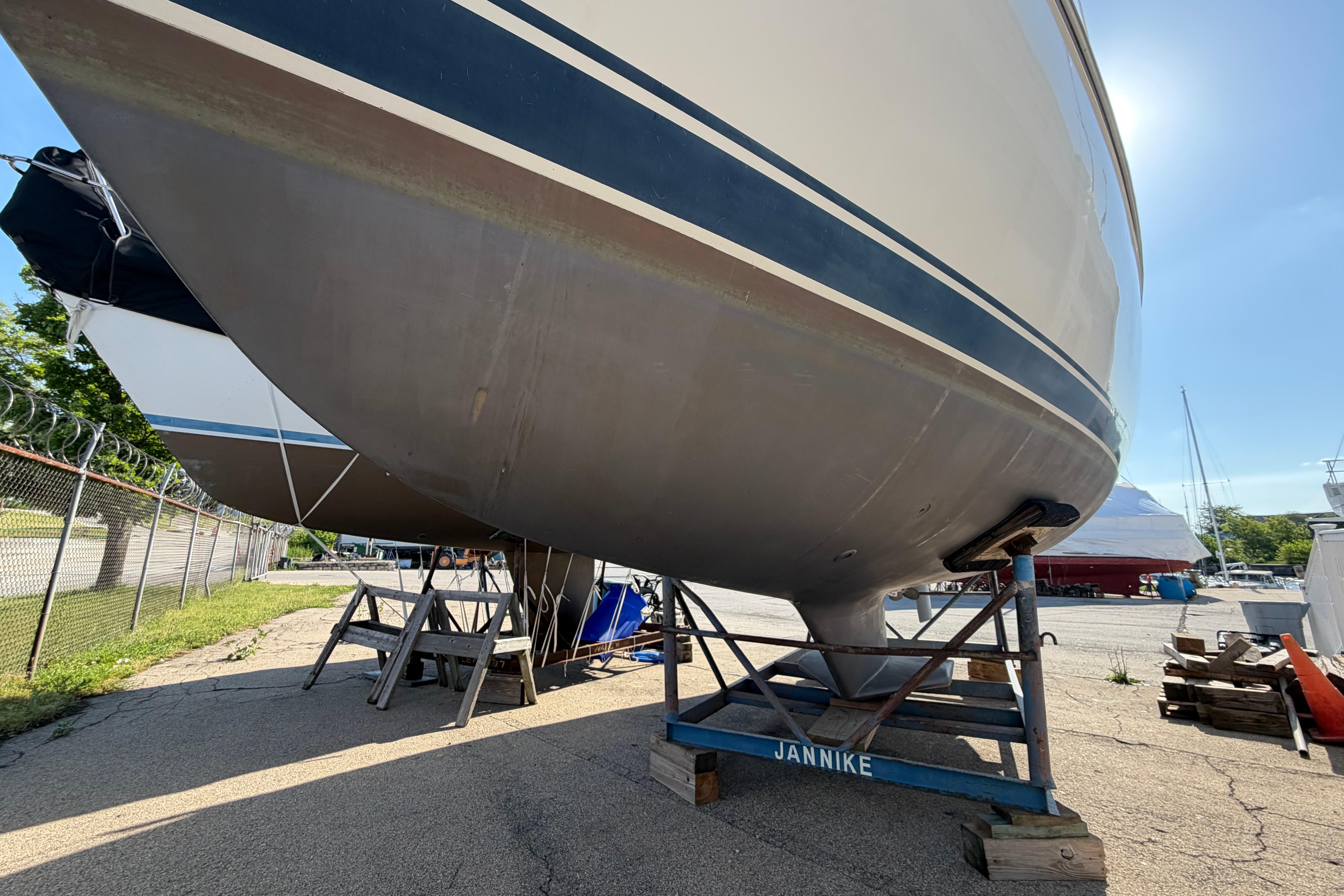 1988 Catalina 30 MkII sailboat on stands in a boatyard, sunny day.
