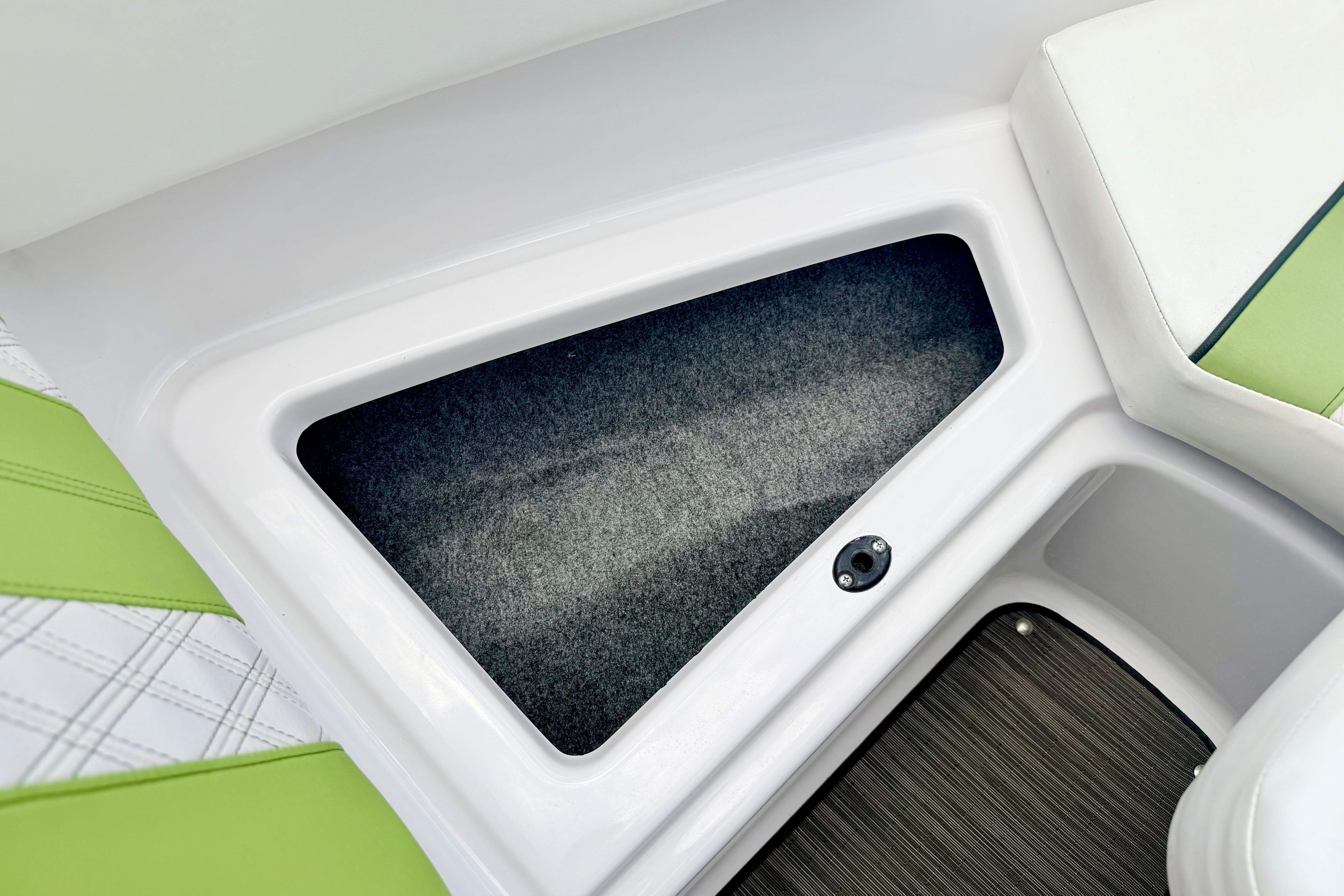 2018 Glastron GT 185 boat interior storage compartment with green and white seating.