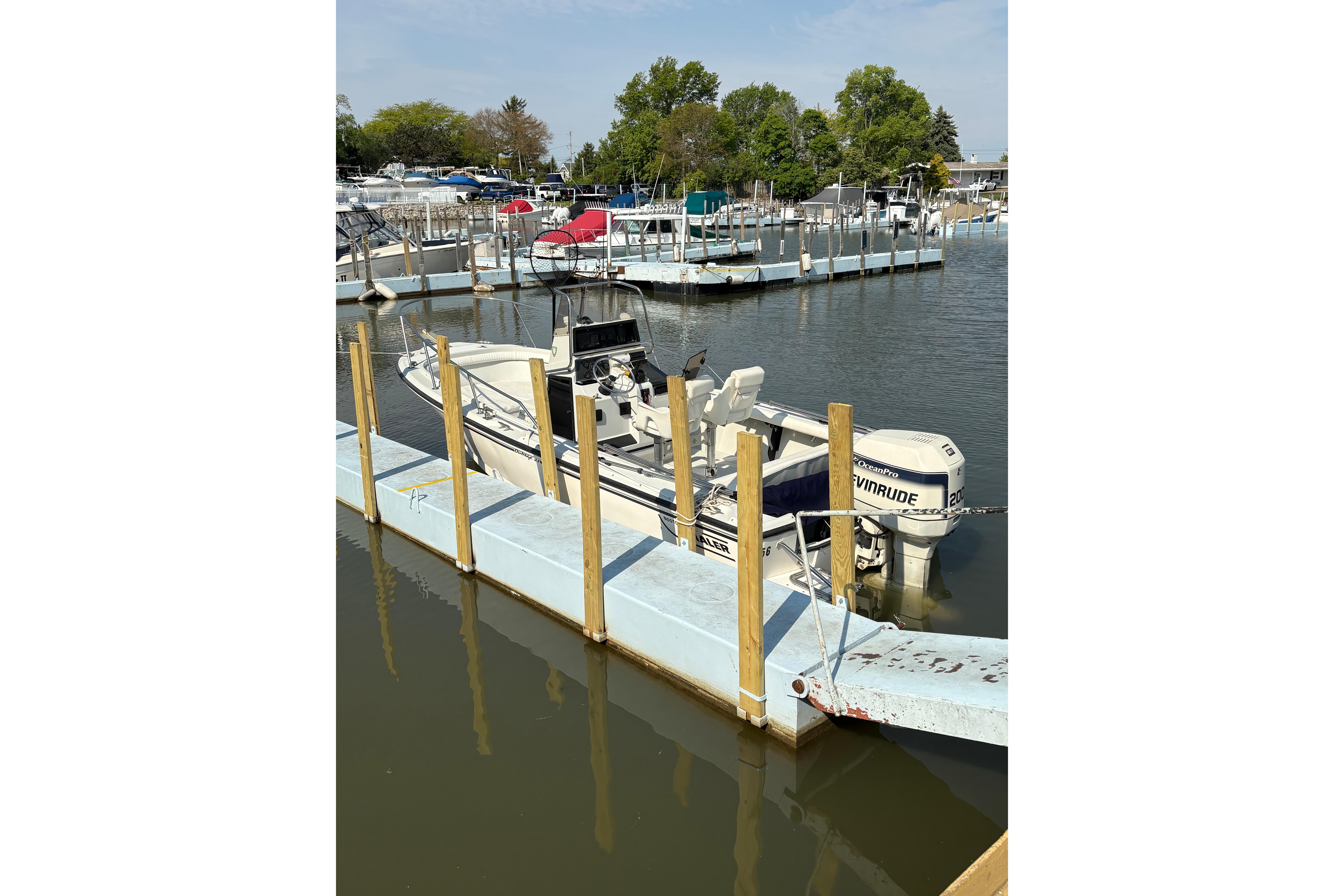 1993 Boston Whaler 21 Outrage docked at a marina with Evinrude outboard motor.