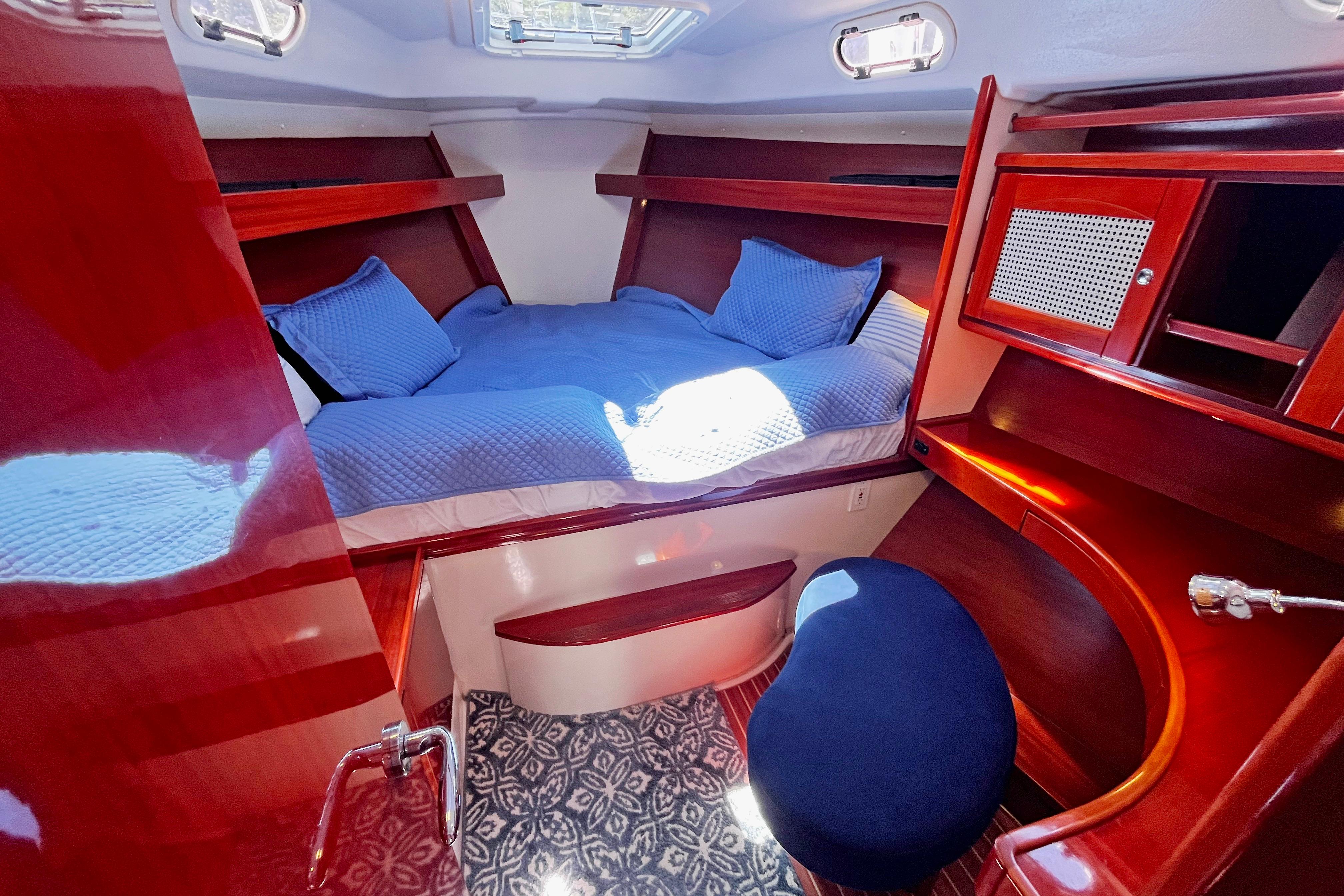 Luxurious cabin interior of a 2004 Hanse 411 yacht with blue bedding and wooden furnishings.