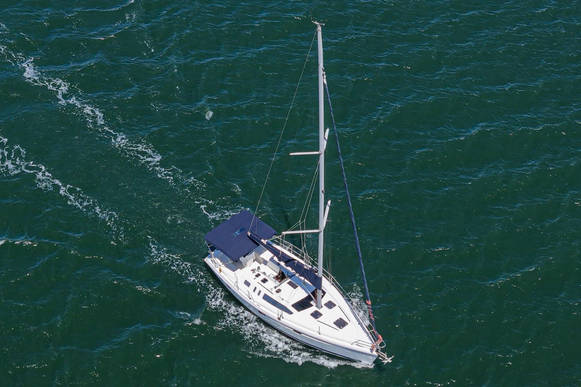 Aerial view of a 1996 Hunter 376 sailboat navigating through deep blue waters.
