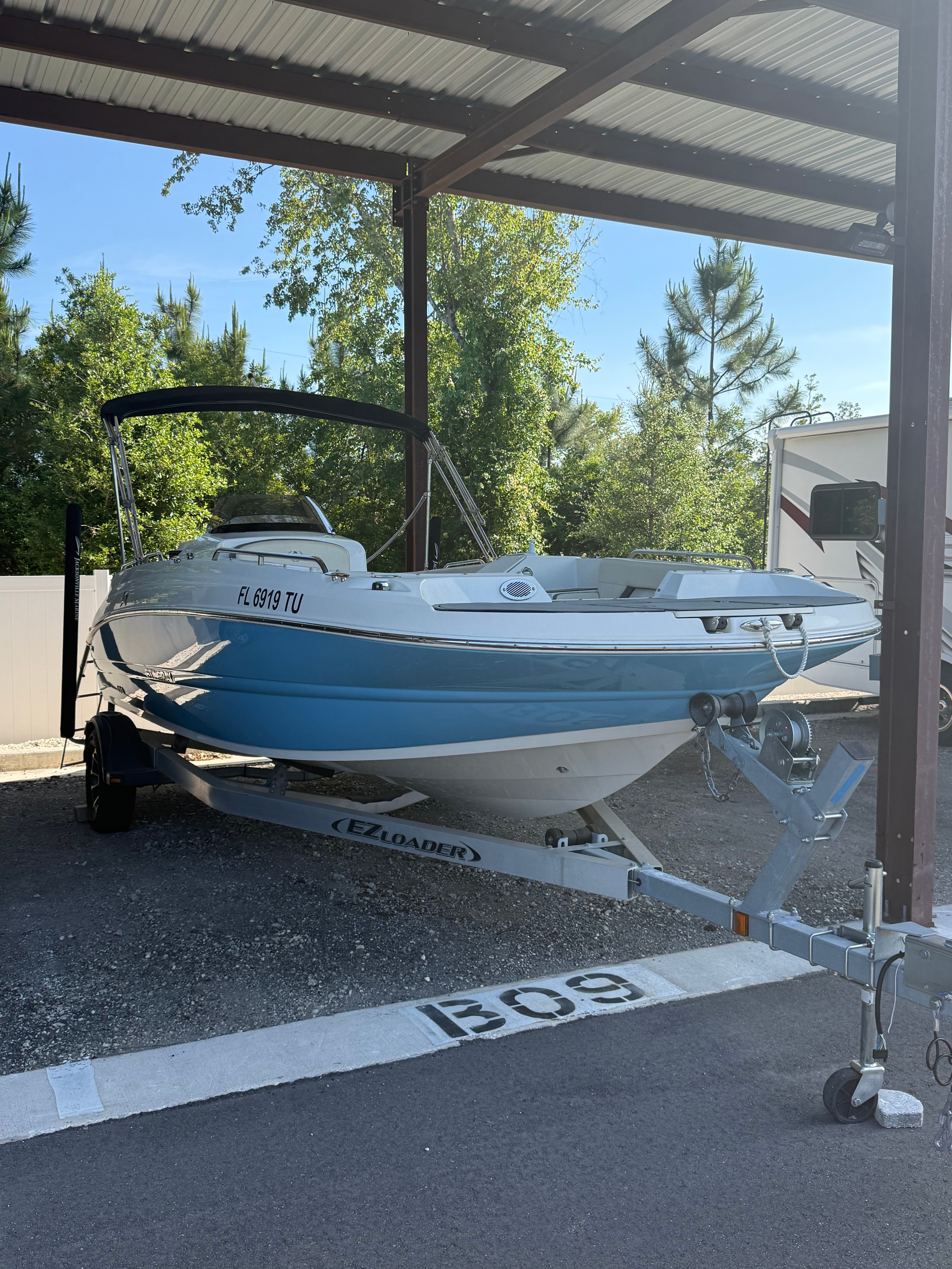 2023 Stingray 192 SC boat on trailer under carport.