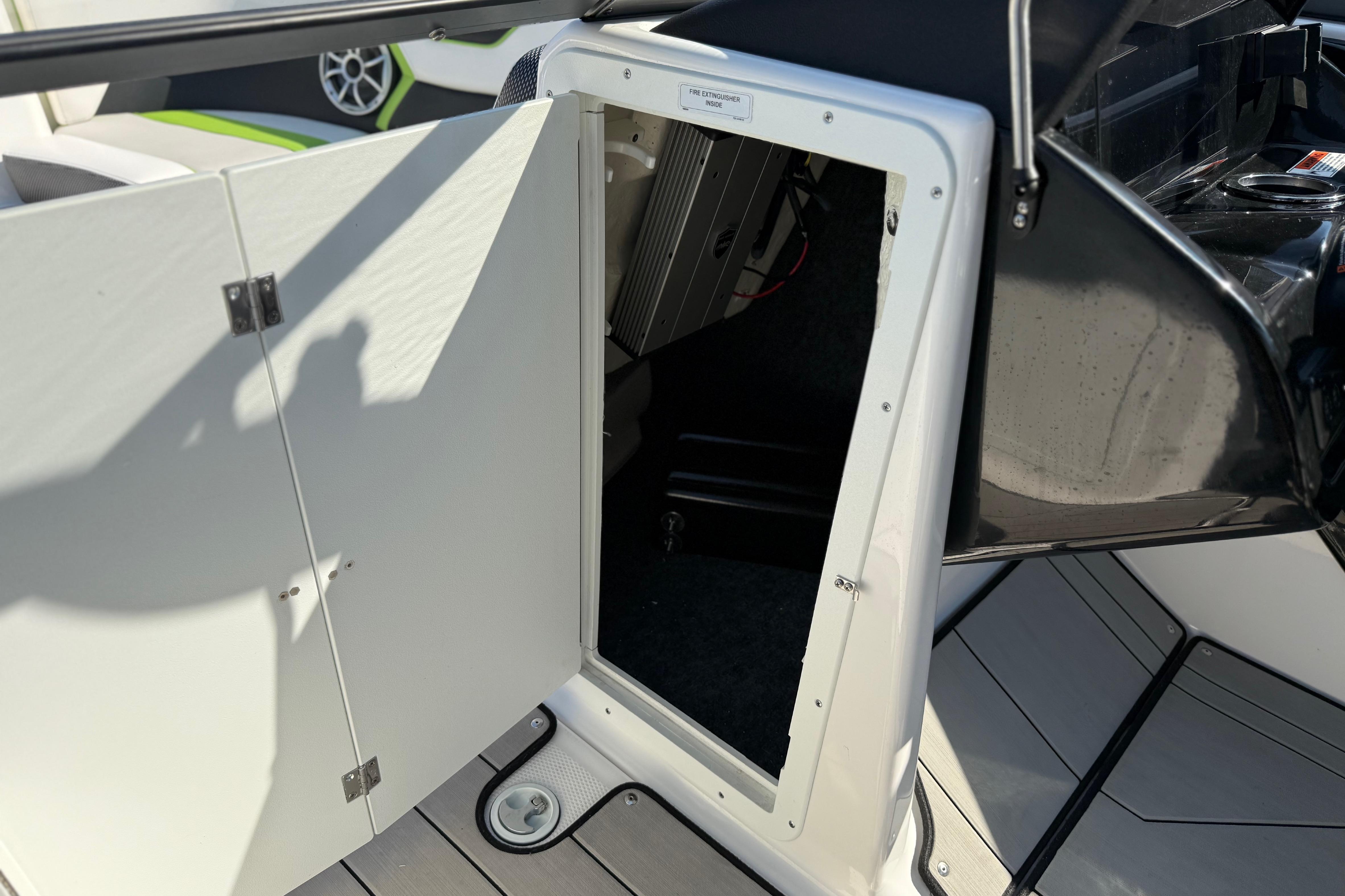 Open storage compartment on 2022 Yamaha Boats 212XE, showcasing interior space and design.
