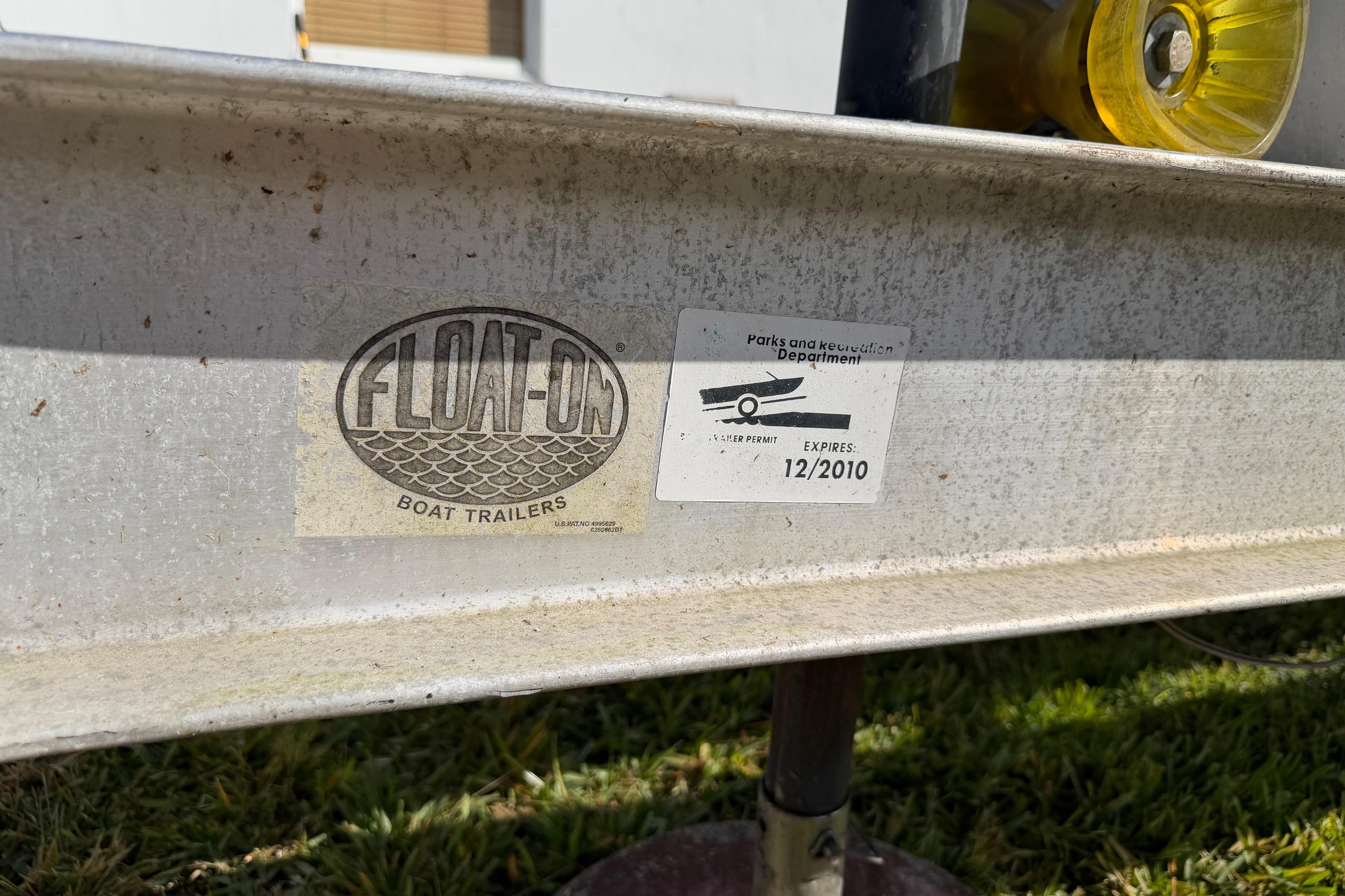 Trailer with "Float-On" logo and expired permit sticker, suitable for 2006 Grady-White Sailfish 282.