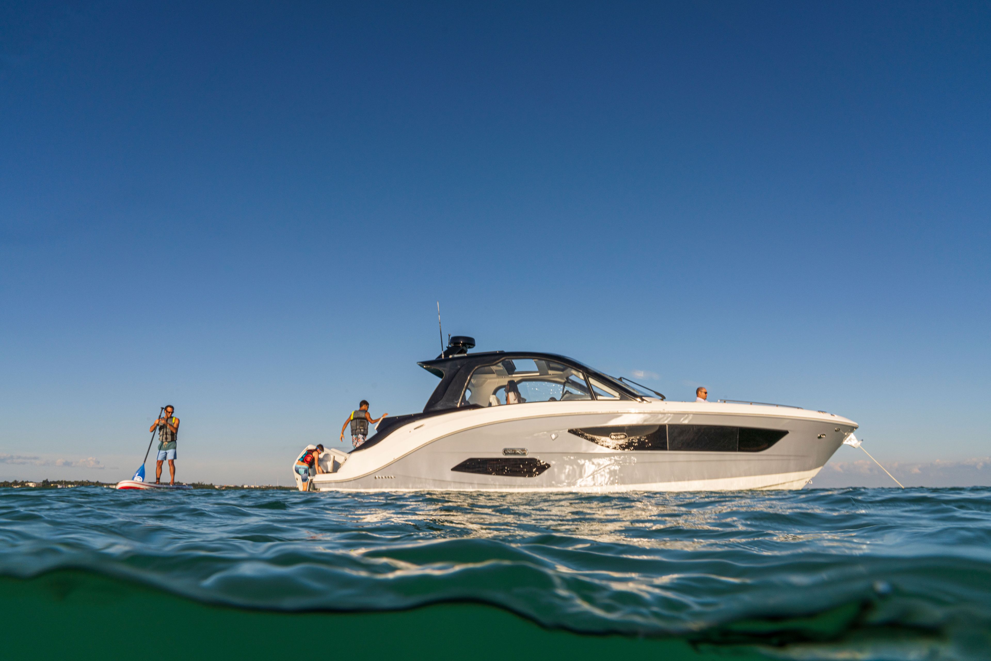 A 2026 Sea Ray Sundancer 370 Outboard on calm water with people on board.
