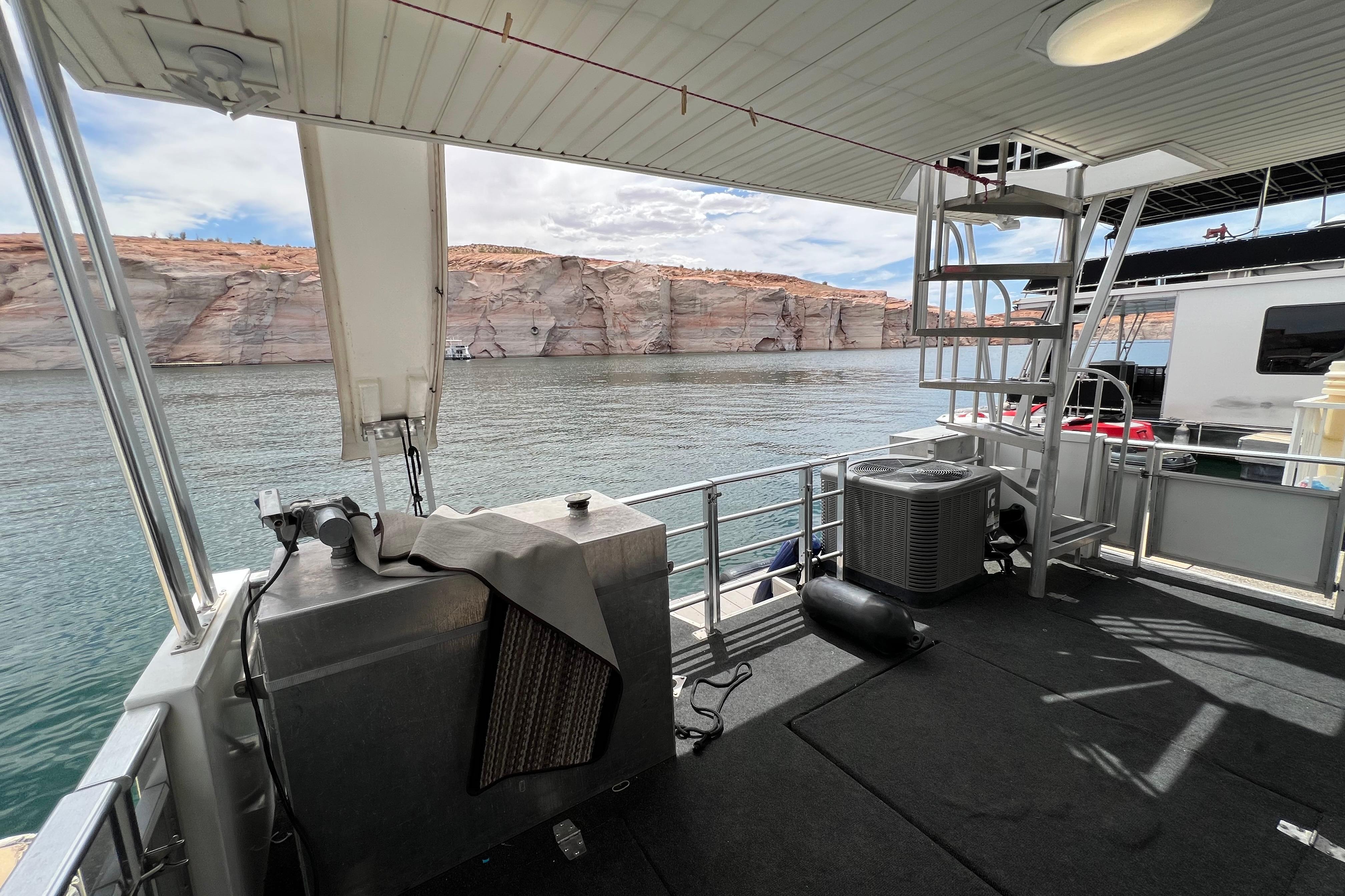 Houseboat deck view with scenic cliffs, featuring Destination Yacht Lotta Yachta 2013 model.