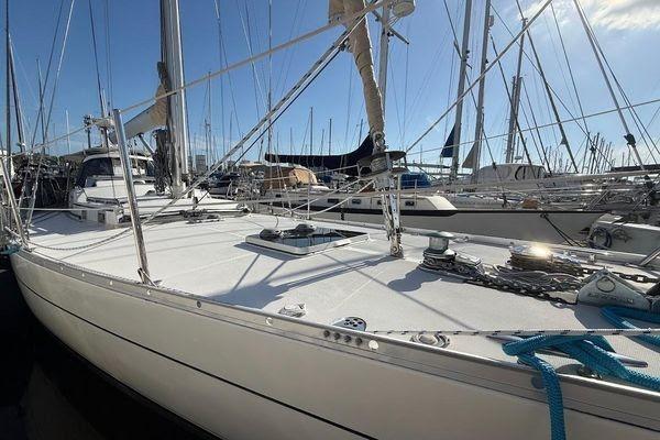 Sailboat in marina, Reliance 44 model, 2011, with blue ropes and clear sky.