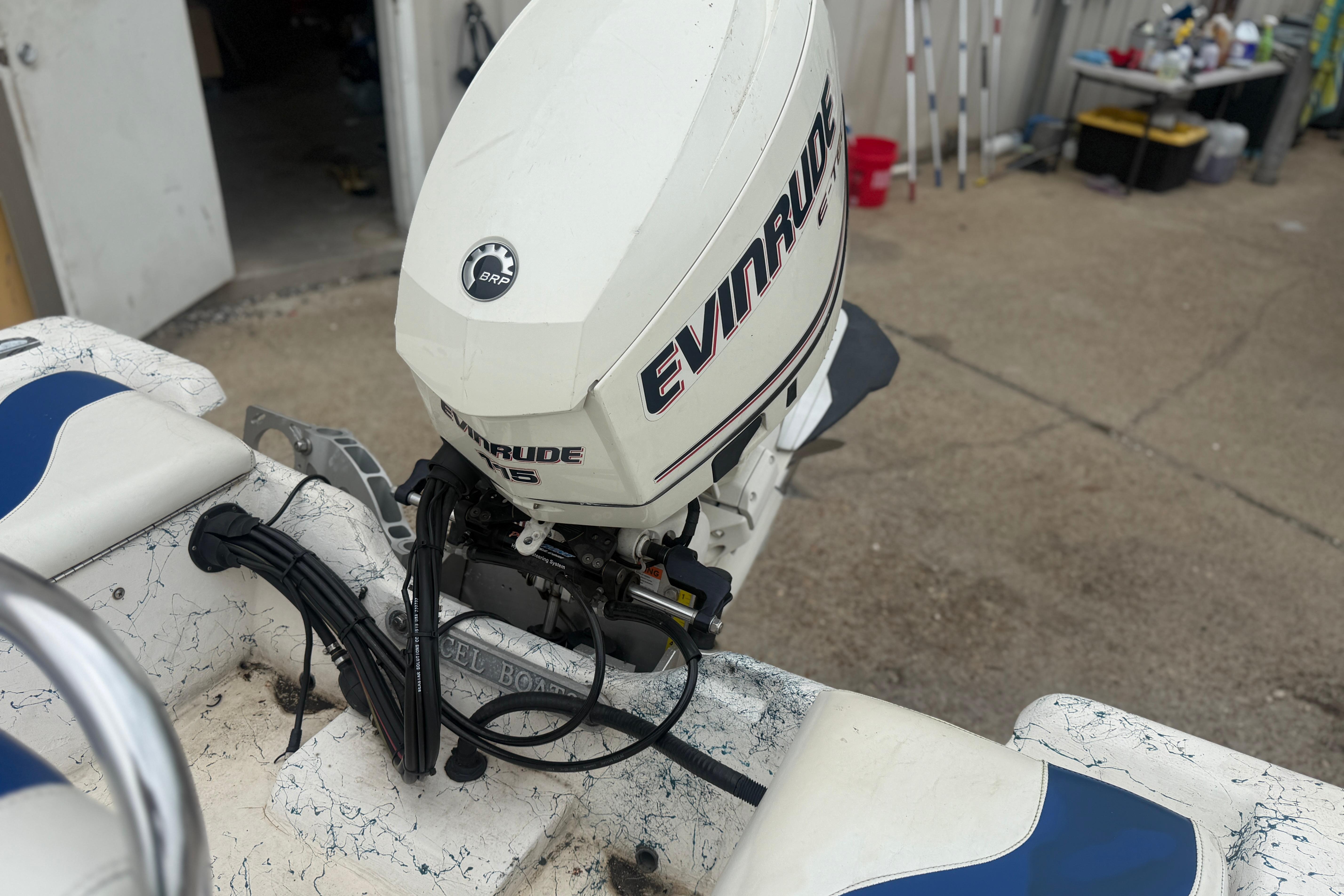 2004 Blue Wave 160 V-Bay boat with Evinrude outboard motor in a garage setting.