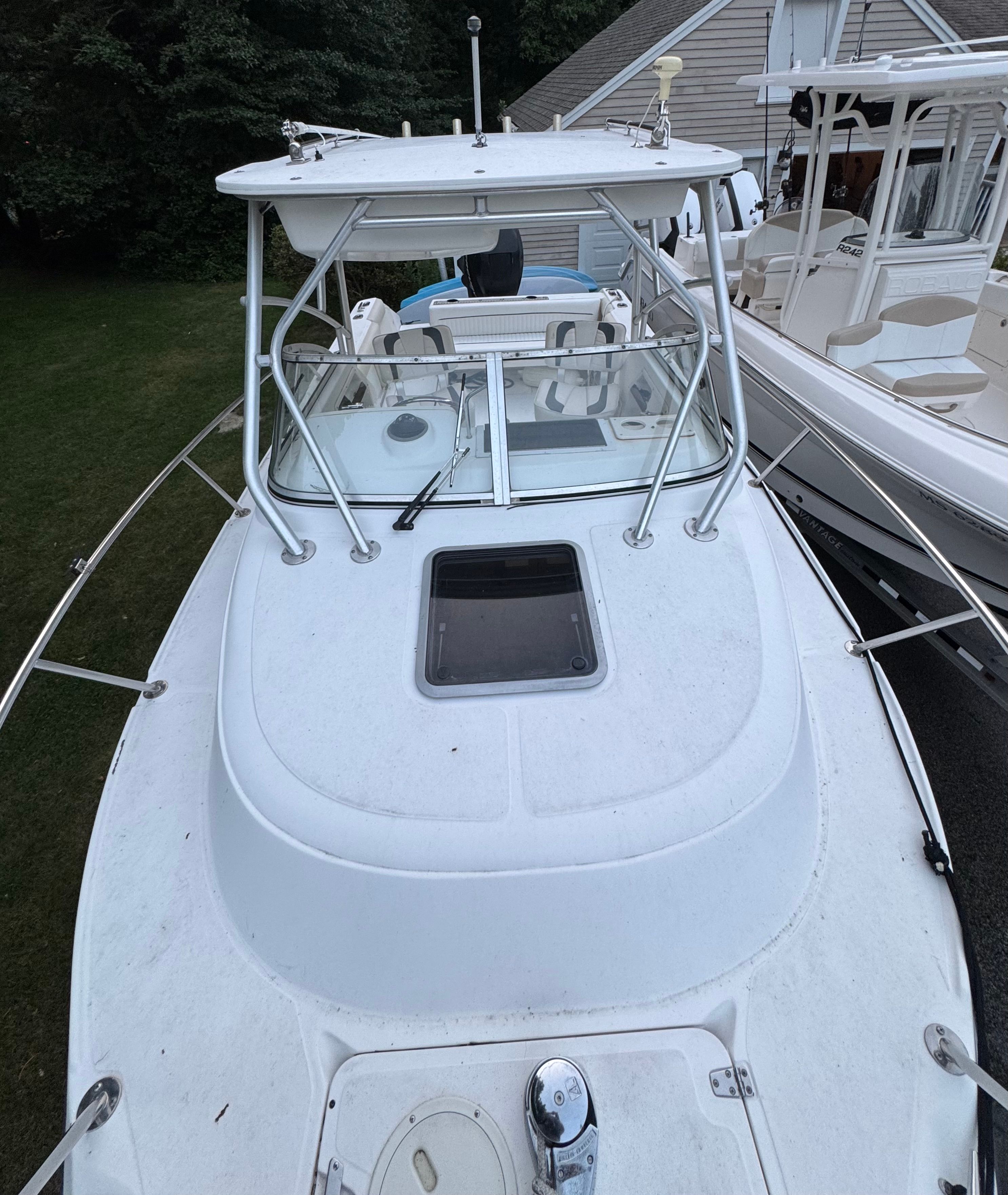 Boston Whaler Conquest 2000 on a trailer beside a house.