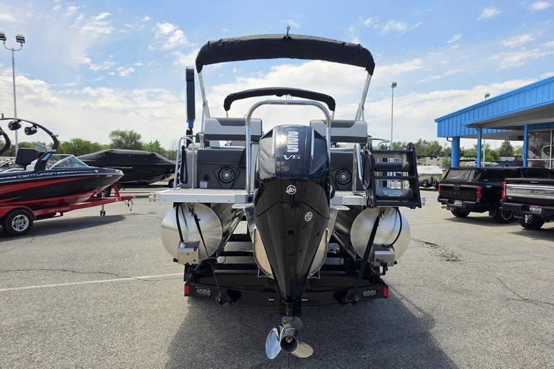 2026 Avalon Catalina Quad Lounge Shift boat with powerful outboard motor in a dealership lot.