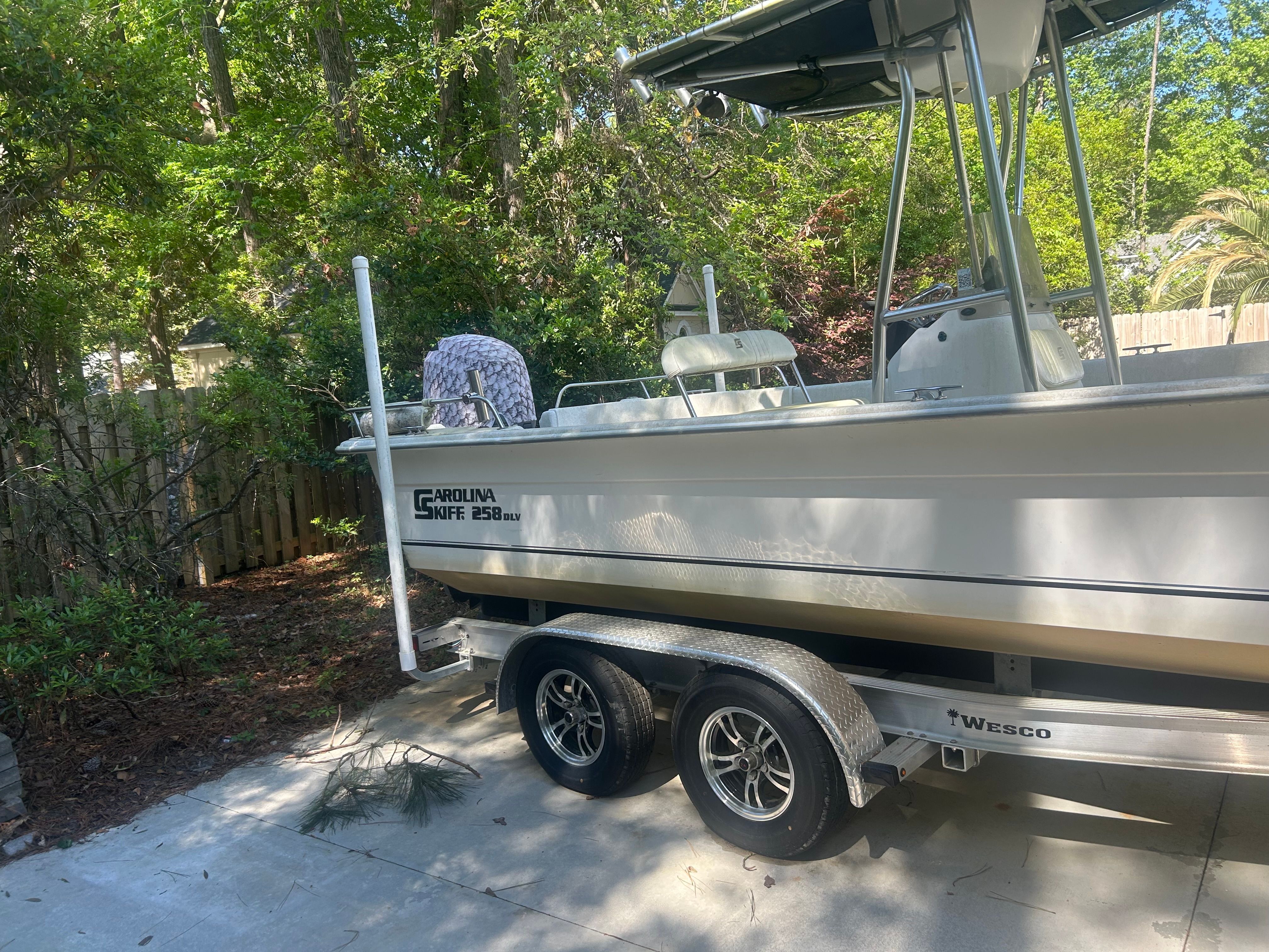 2011 Carolina Skiff 258 DLV boat on trailer in garden.