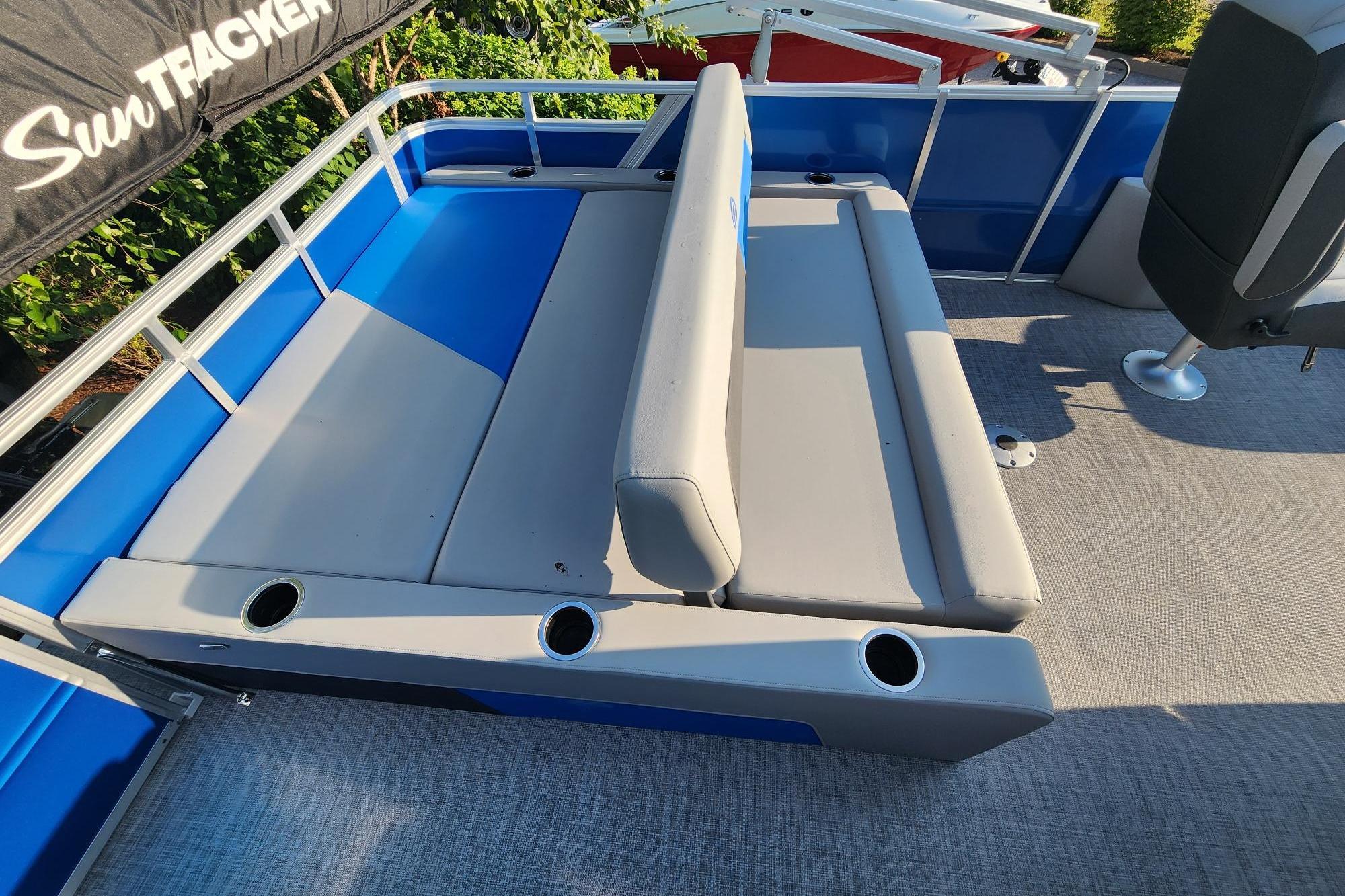 2026 Sun Tracker Party Barge 22 RF DLX interior with gray seating and cup holders.