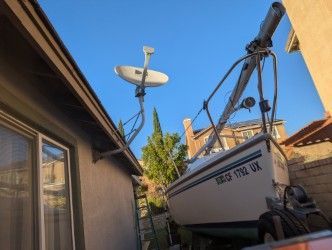 2002 Catalina Capri sailboat beside house and satellite dish.