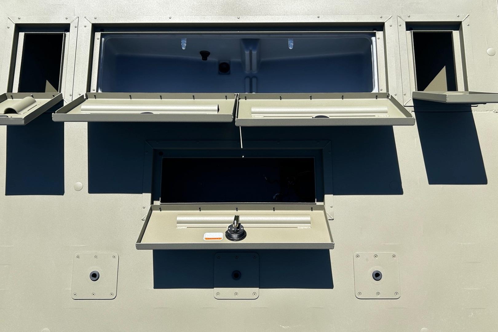 2026 Tracker Grizzly 2072 CC boat with open storage compartments and control panel.