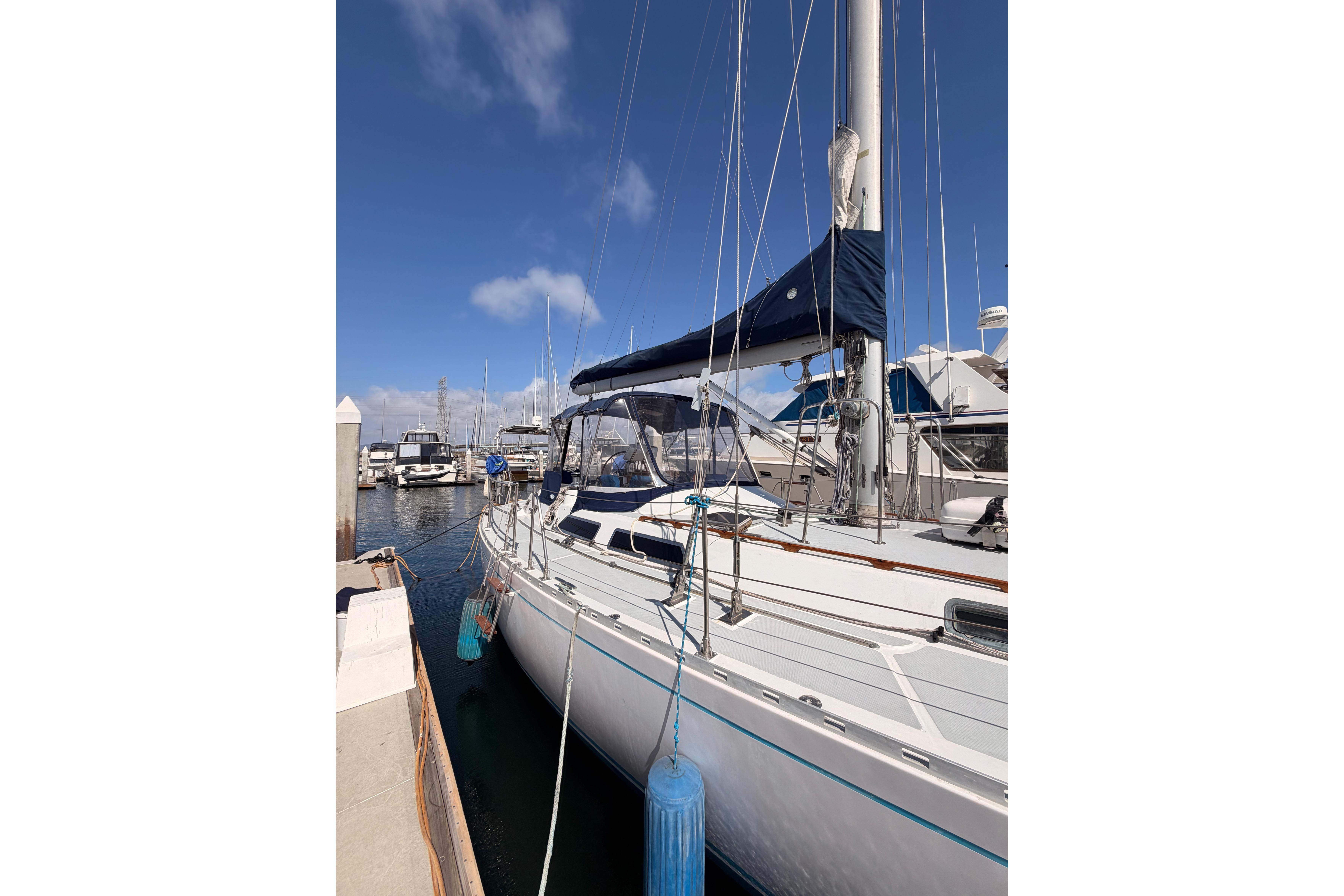 Sailboat docked at marina, 1991 Hylas 51, clear blue sky background.