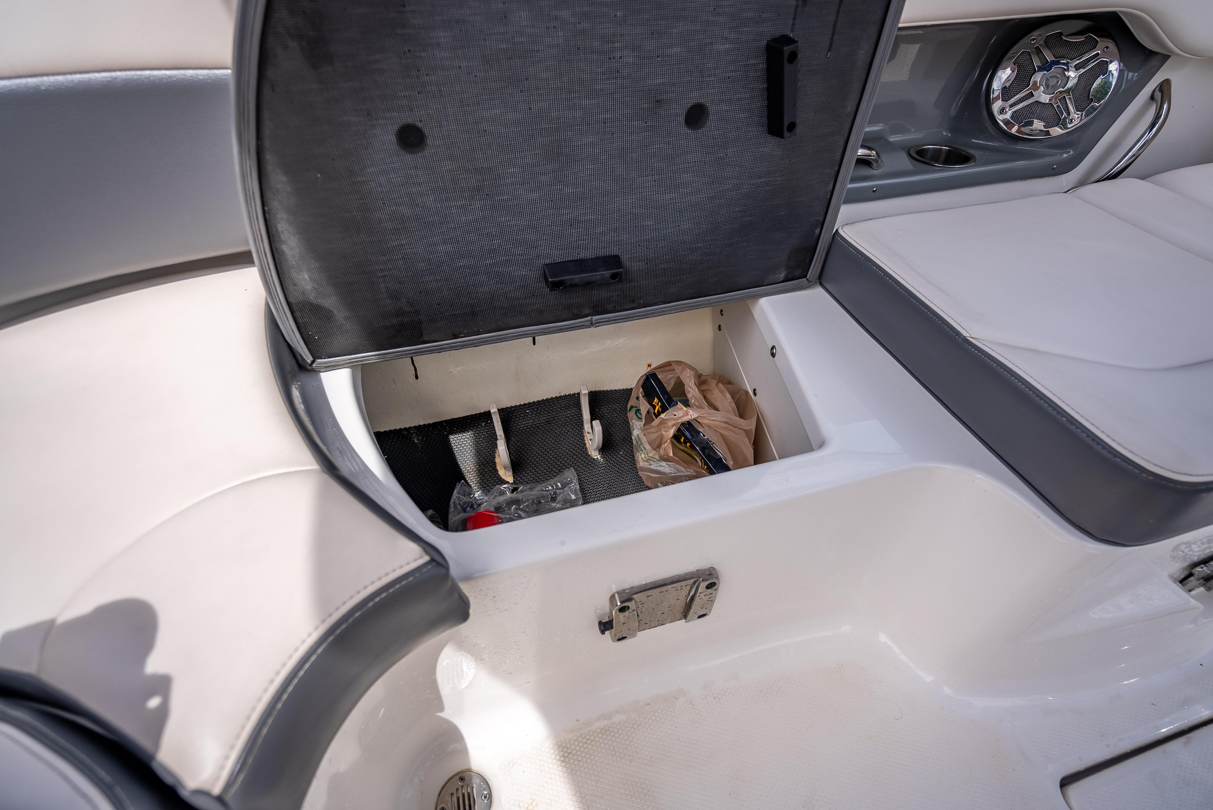 Open storage compartment in 2017 Chaparral 227 SSX boat with seating and speaker.