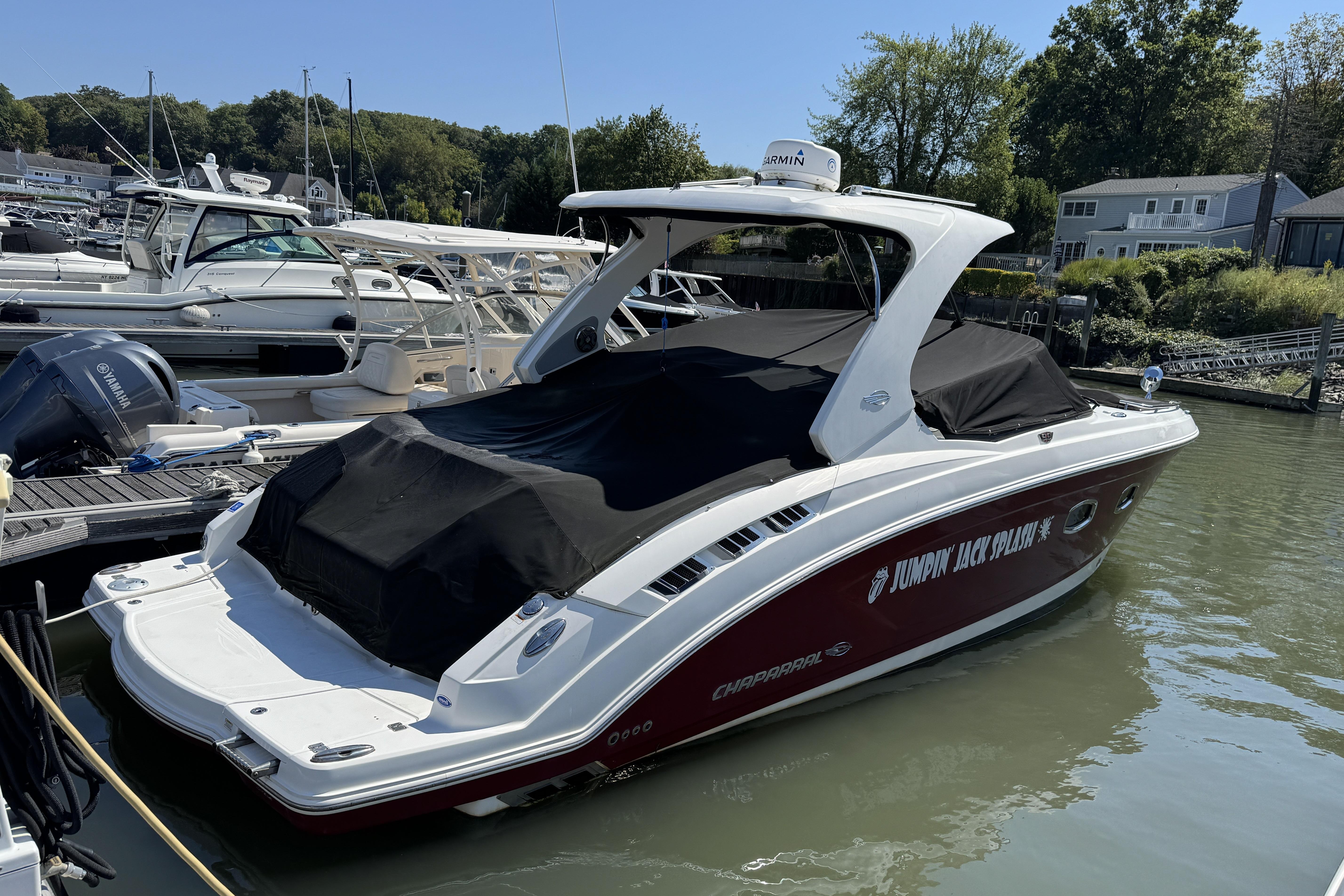 2012 Chaparral 327 SSX boat docked, covered, with "Jumpin' Jack Splash" text on the side.