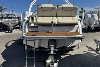 2019 Bryant Calandra 23 boat, rear view with seating and motor, parked outdoors.