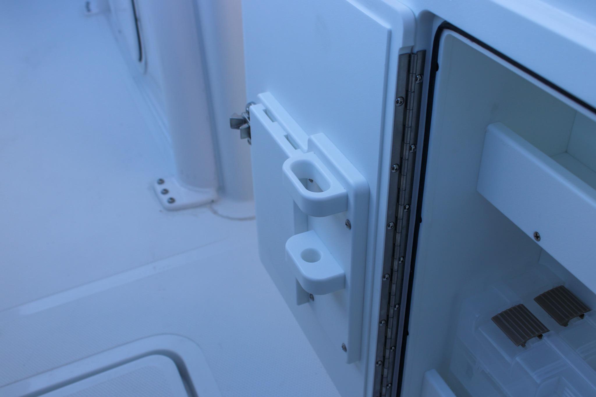 Open storage compartment on 2026 Sea Hunt Gamefish 25 boat, showcasing interior details.