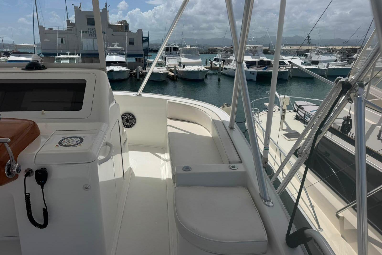Flybridge view of 2012 Viking 50 Convertible yacht docked at marina.