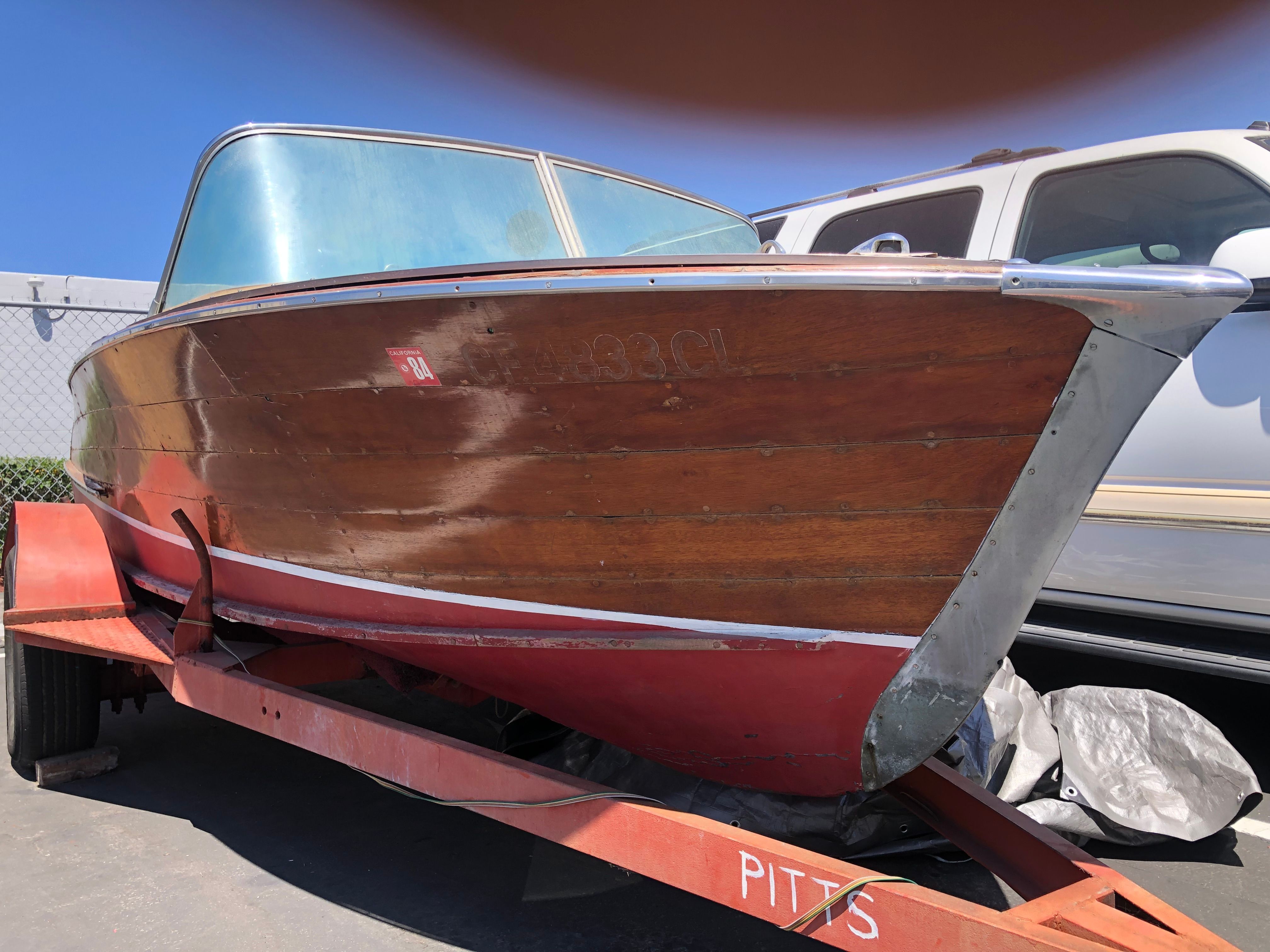 A 1960 Century Resorter on a trailer, featuring wooden paneling and a red hull.