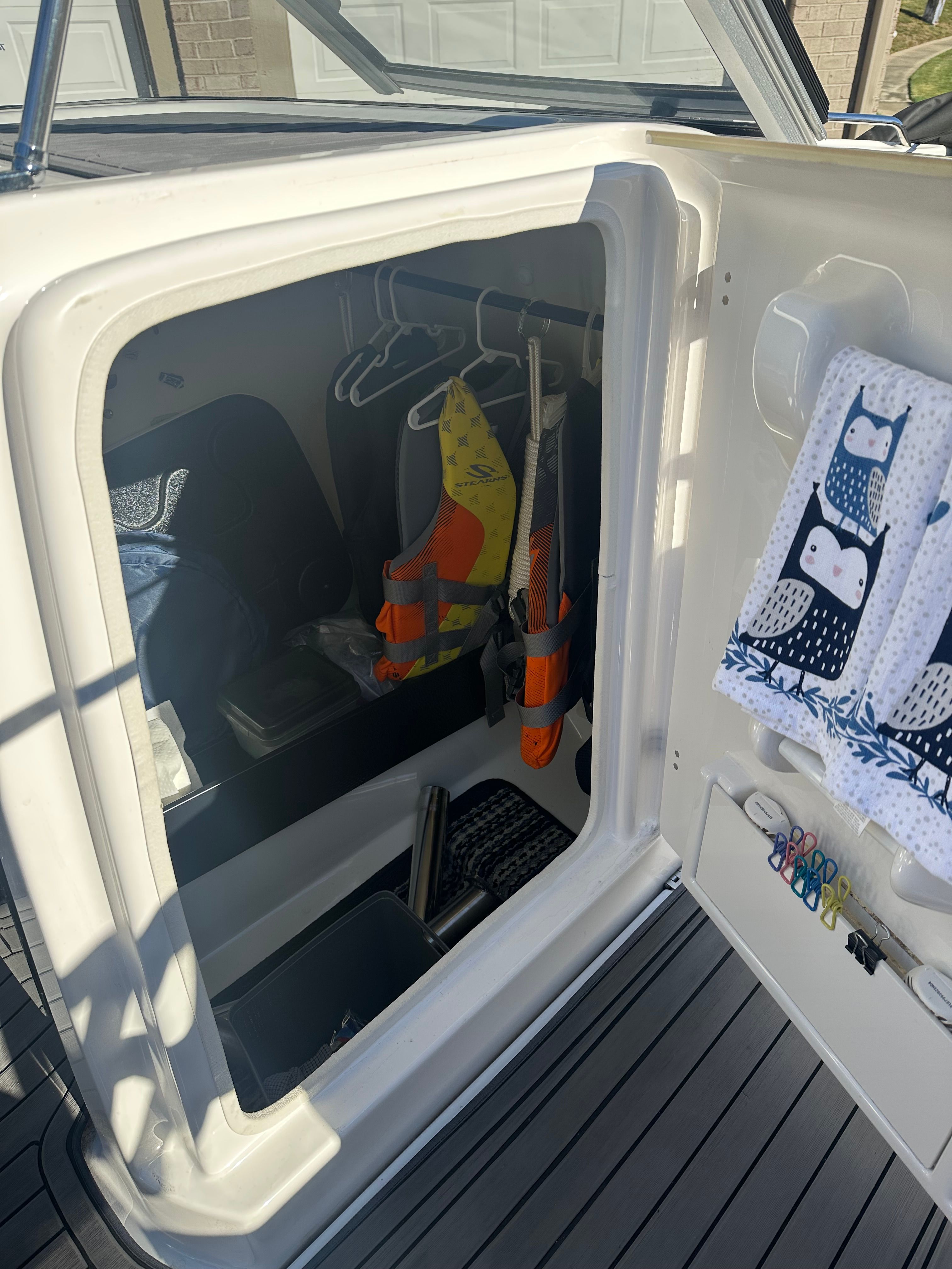 A storage area on a boat with life jackets and towels.