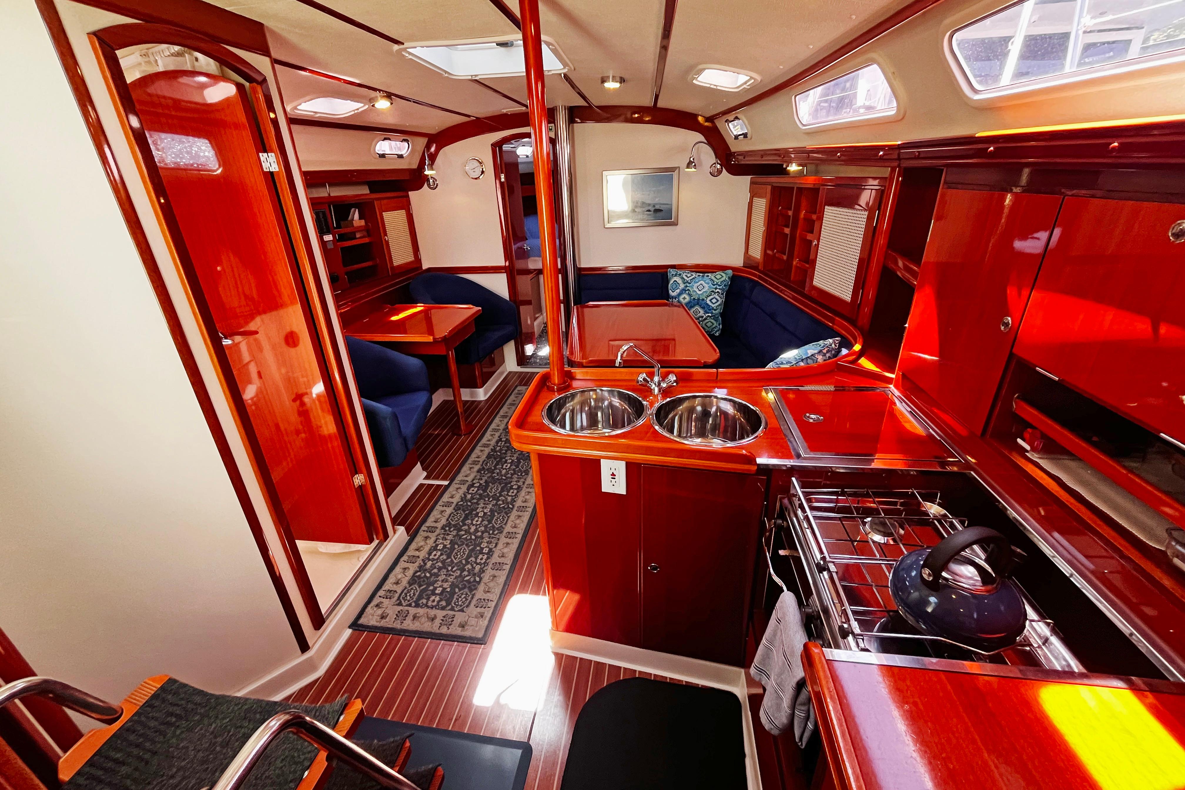 Luxurious 2004 Hanse 411 yacht interior with polished wood, cozy seating, and modern kitchen amenities.
