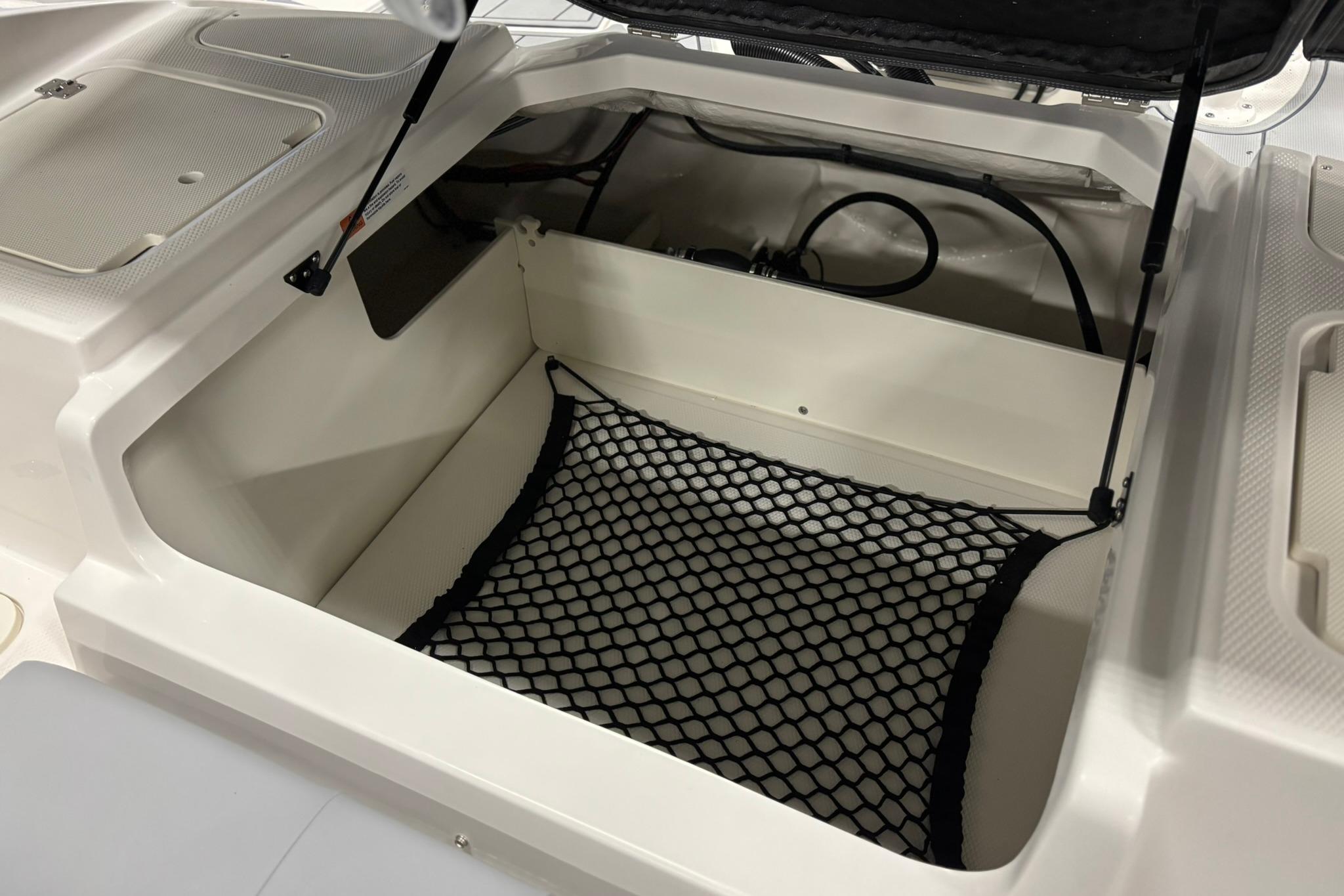2026 Chaparral 21 SSi OB boat storage compartment with netting and hydraulic lift.