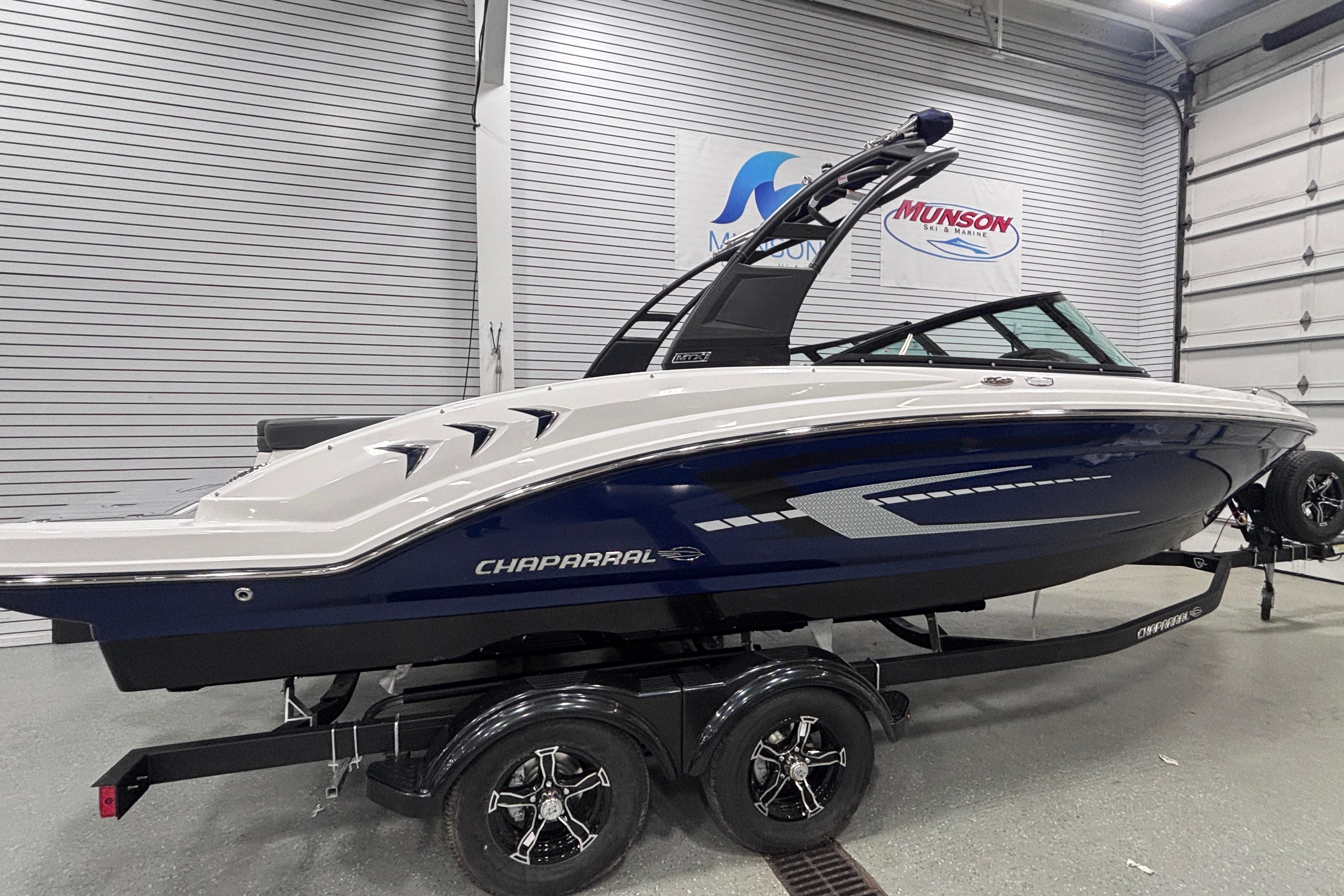 2026 Chaparral 23 SSi boat on trailer in showroom, side view.