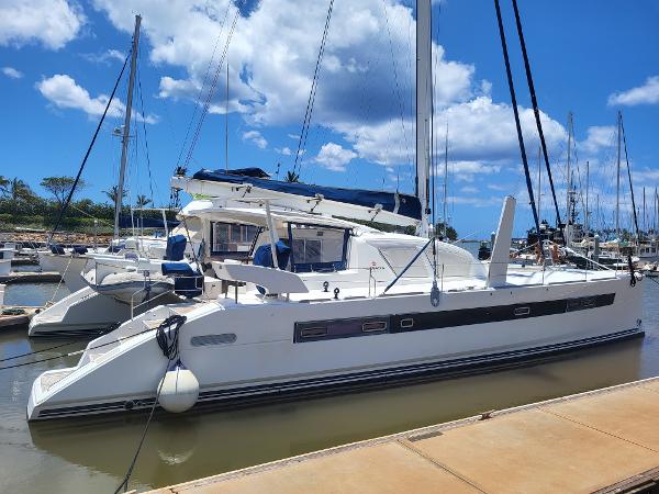 2009 Catana 65 catamaran docked at a marina under a clear blue sky.