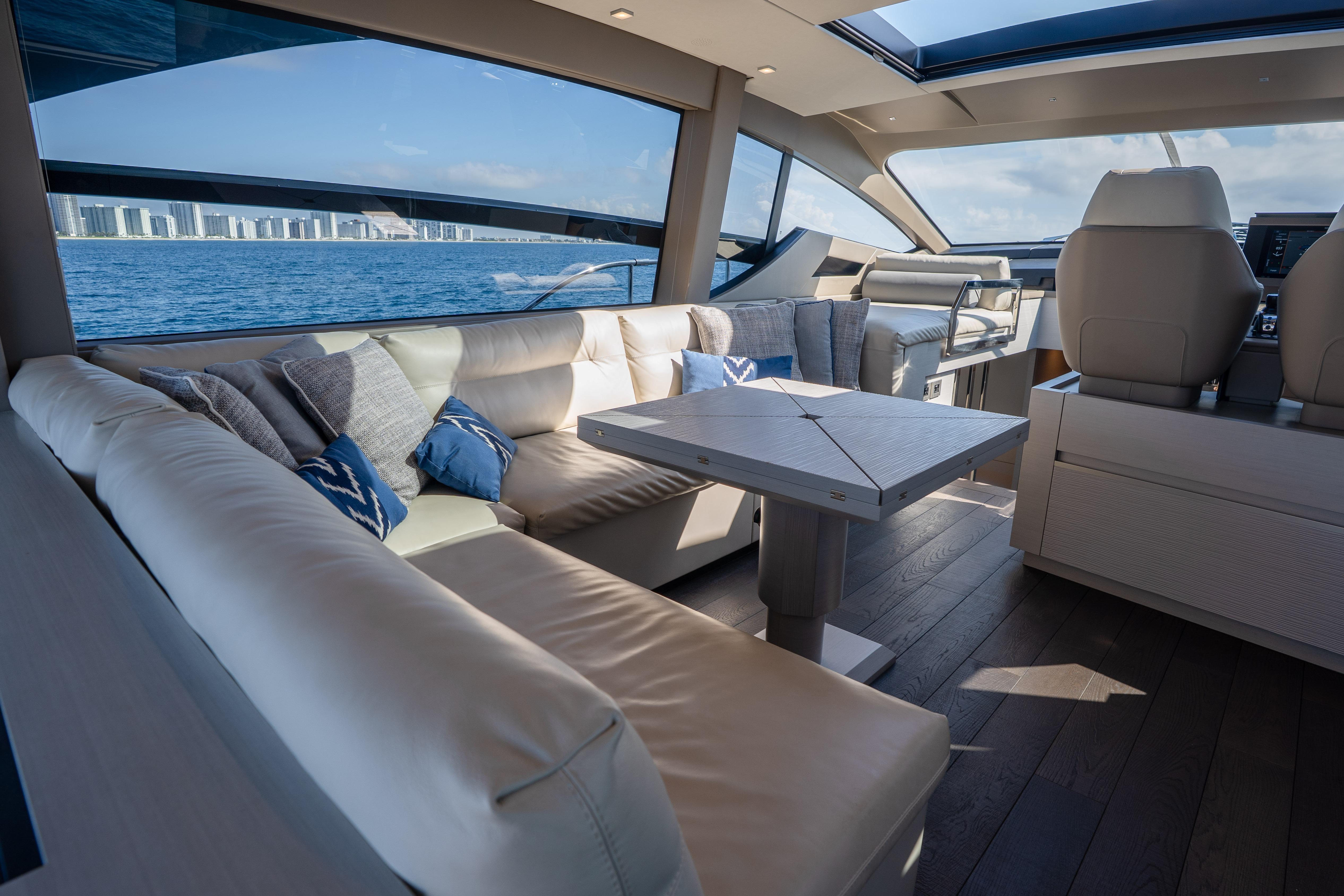 Luxurious interior of 2024 Pershing 7X yacht with ocean view and modern seating.