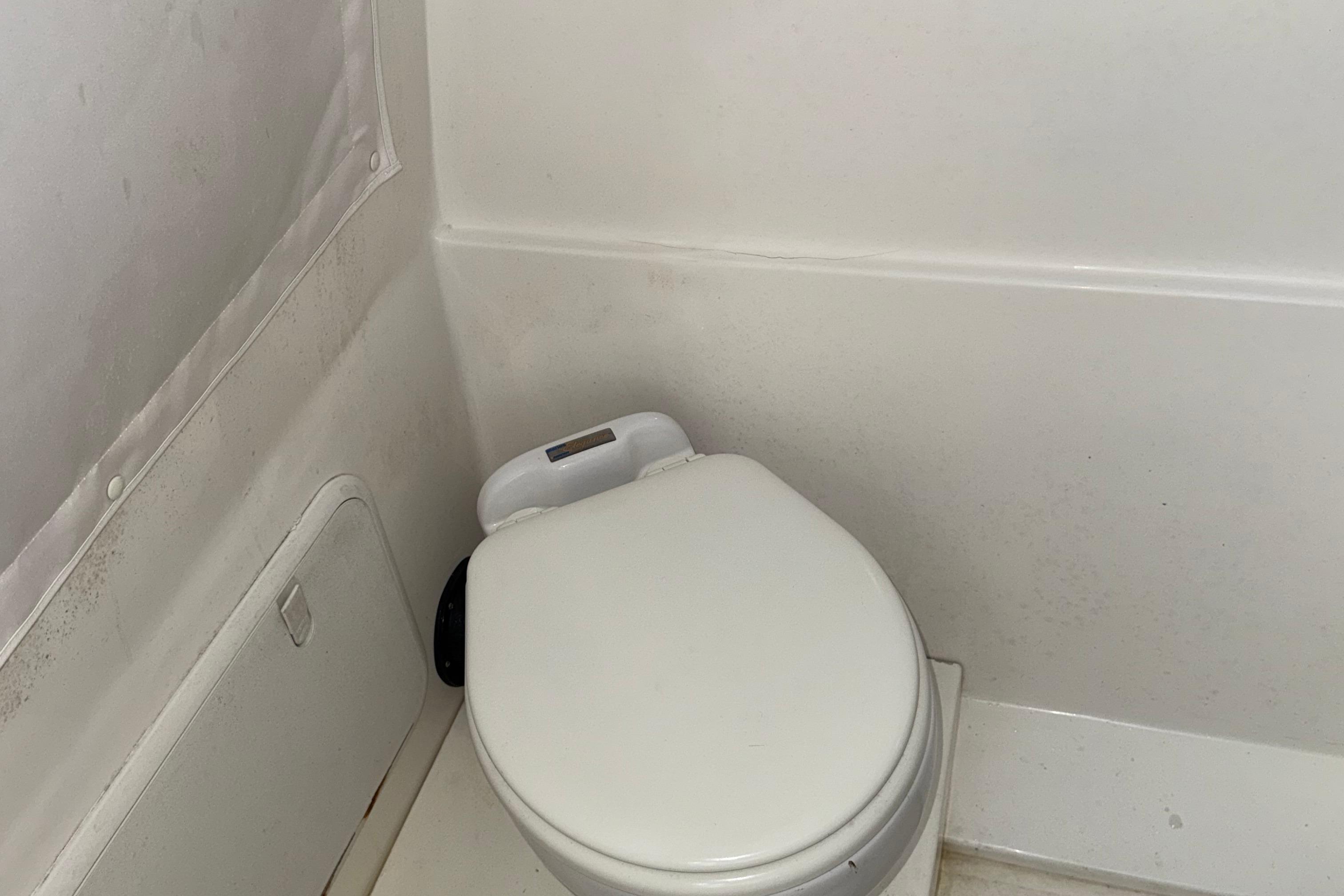 2021 Marlin 39 CC boat bathroom with compact white toilet.