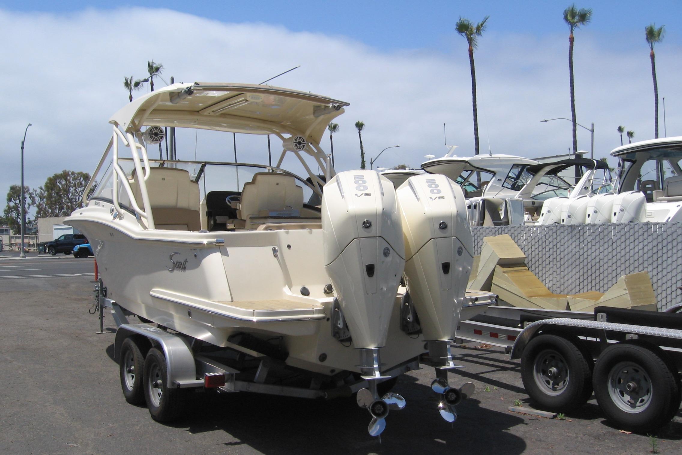 2024 Scout 255 Dorado boat on trailer, featuring dual outboard engines, parked at marina.