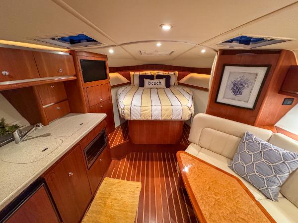 Luxurious 2006 Tiara Yachts 3200 Open cabin with cozy bed and elegant wood finishes.