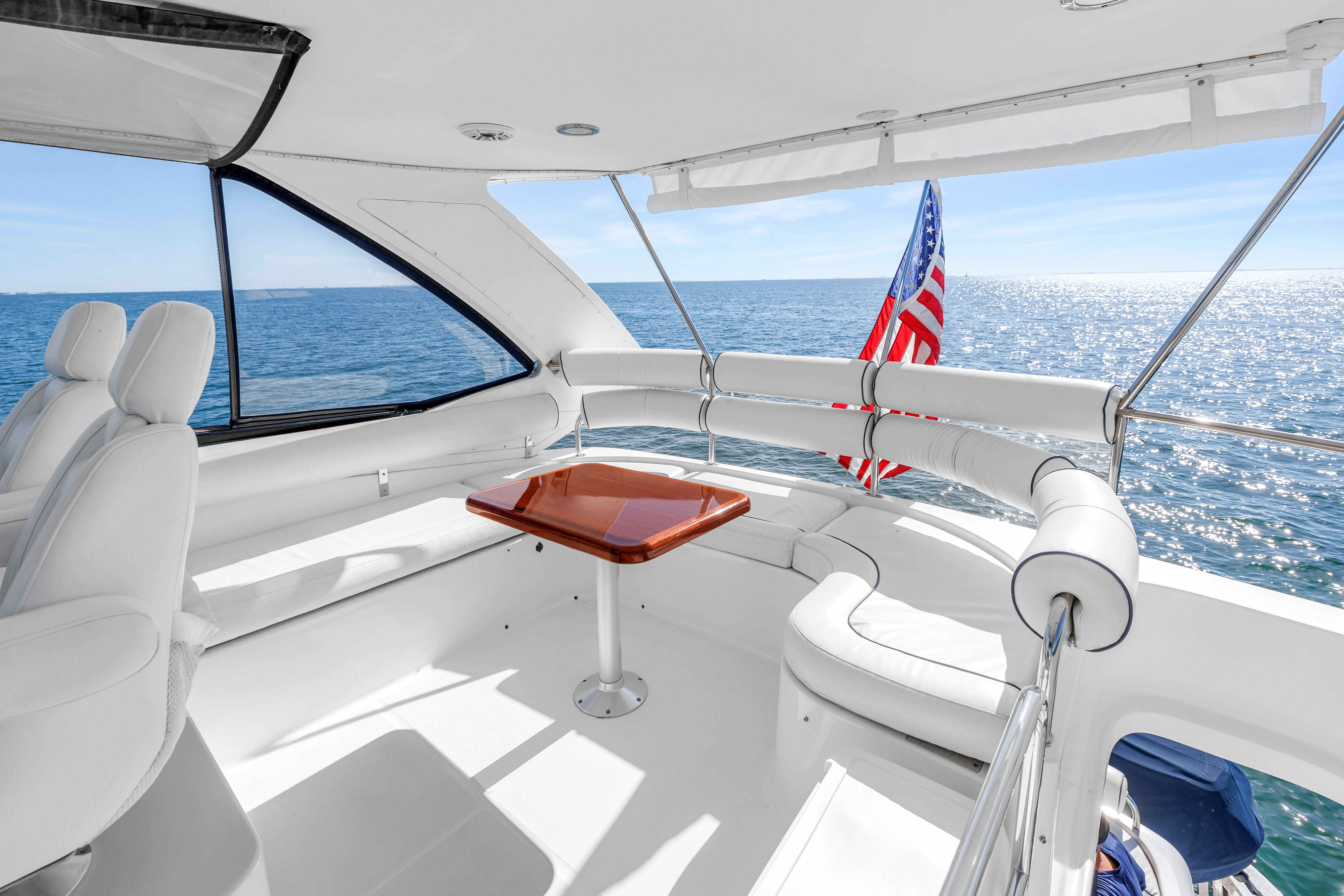 Luxurious 2001 Neptunus 56 Flybridge yacht interior with ocean view and American flag.