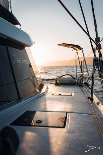 Sailing on a 2025 Nautitech 44 Open catamaran at sunset, ocean view.