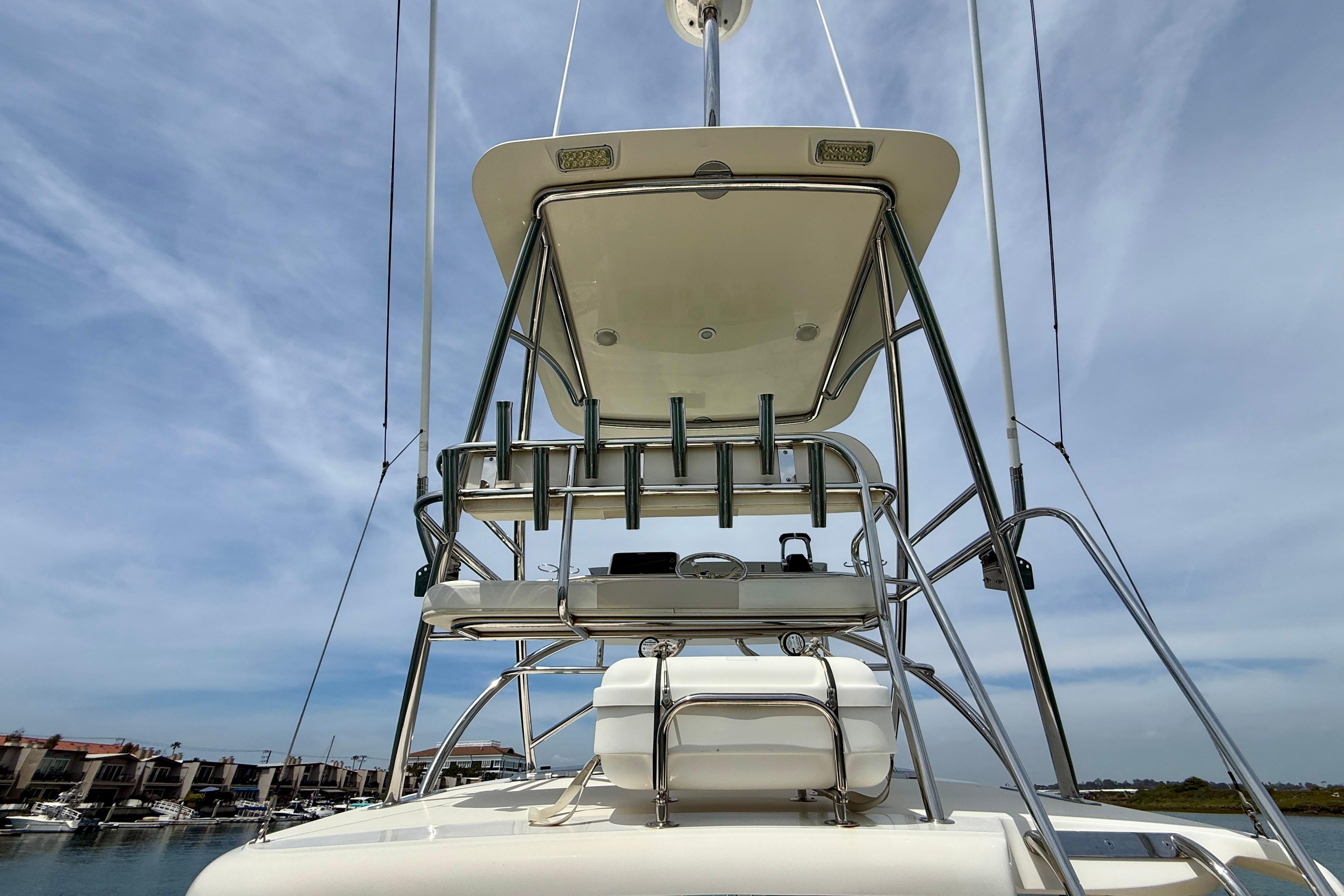2012 Pursuit OS 345 Offshore boat tower with rod holders under a clear sky.